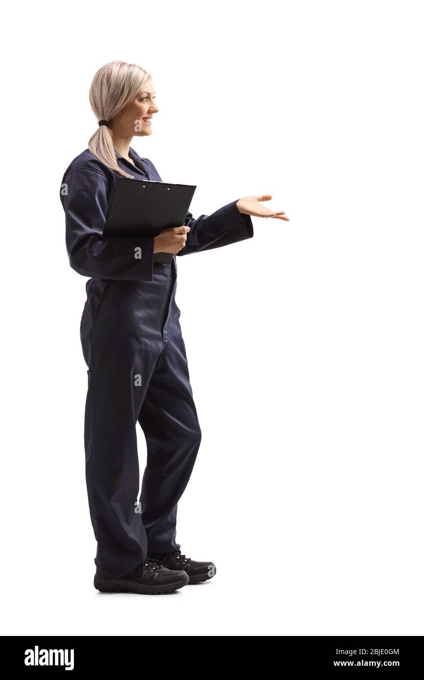 Profil complet tiré d'une jeune femme ouvrier dans un uniforme général tenant un presse-papiers avec document isolé sur fond blanc Banque D'Images