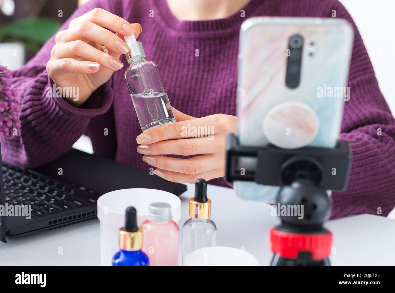 Sérum en beauté blogger mains femelles. Enregistrement de contenus vidéo en ligne d'esthéticienne, revue de diffusion en direct sur des produits cosmétiques. Formation en cosmologie Banque D'Images