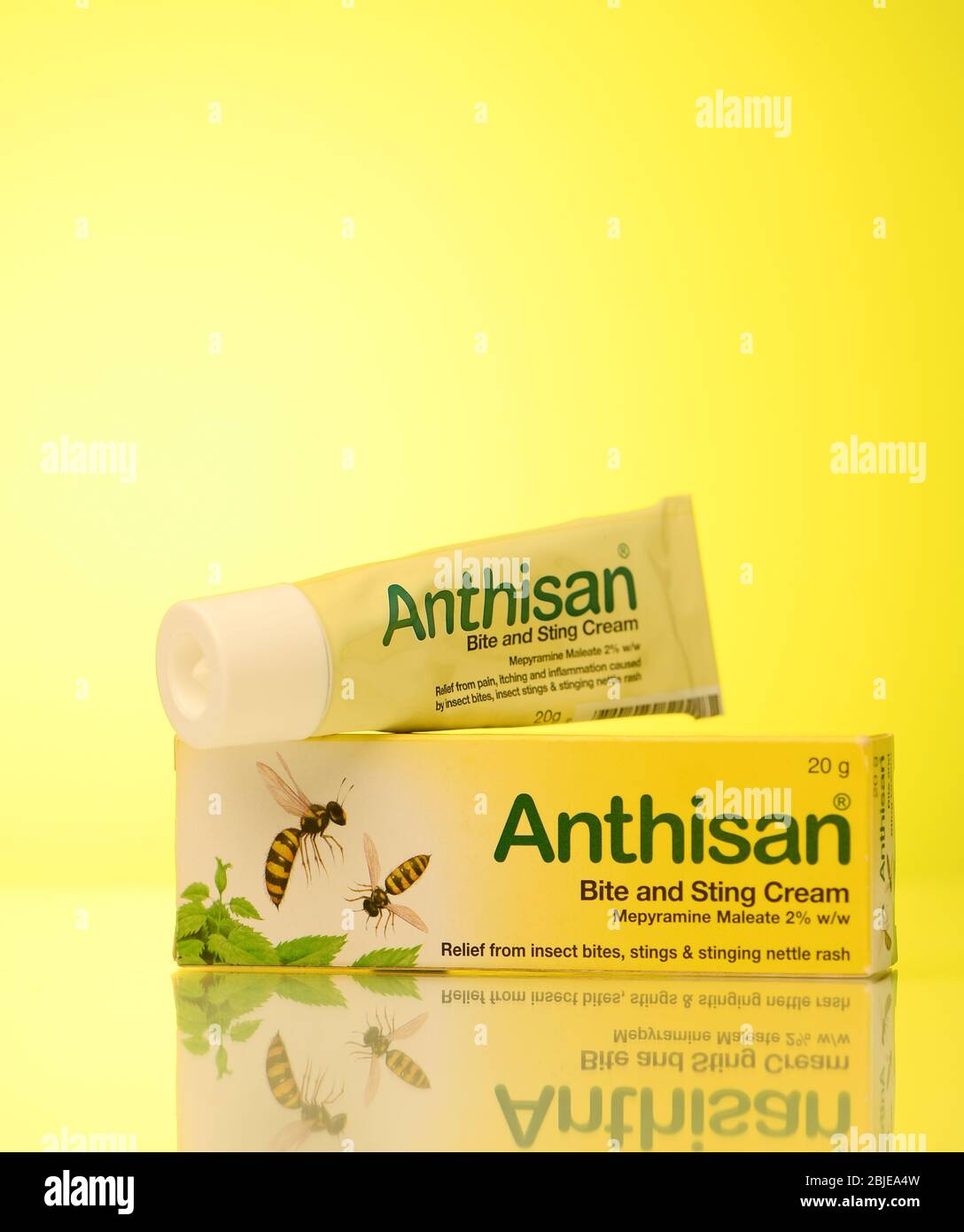 Paquet de morsure et de crème de piqûre d'anthisan sur un fond jaune photographié dans le studio avec une réflexion. Banque D'Images