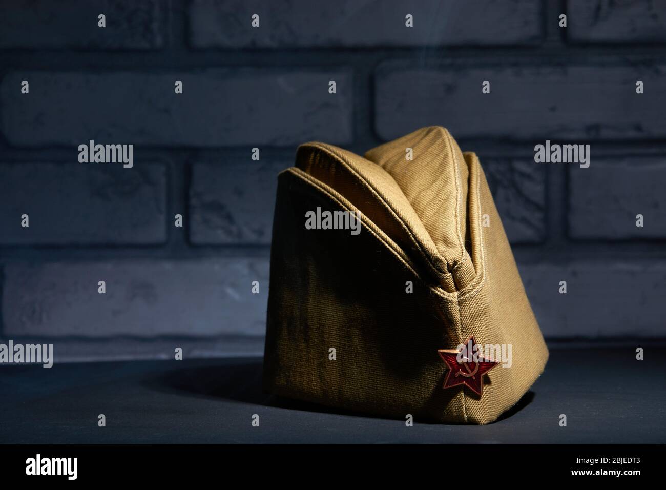 Un ancien chapeau militaire soviétique de kaki sur fond de brique.  Symbolisme 9 mai Photo Stock - Alamy