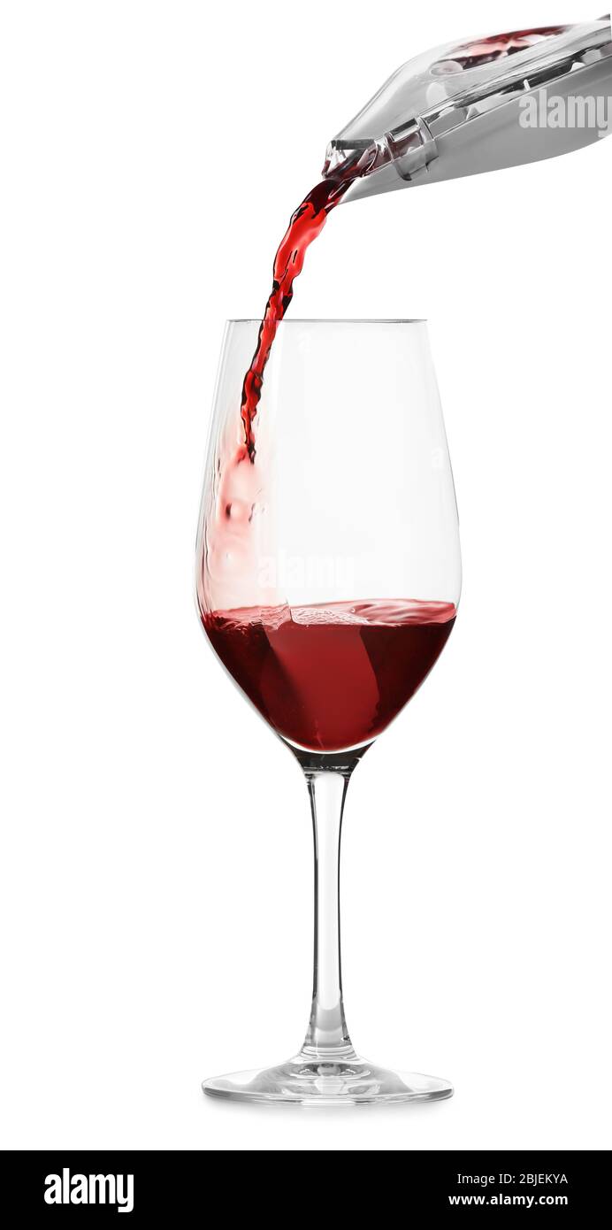 Verser le vin rouge dans un verre sur fond blanc Banque D'Images