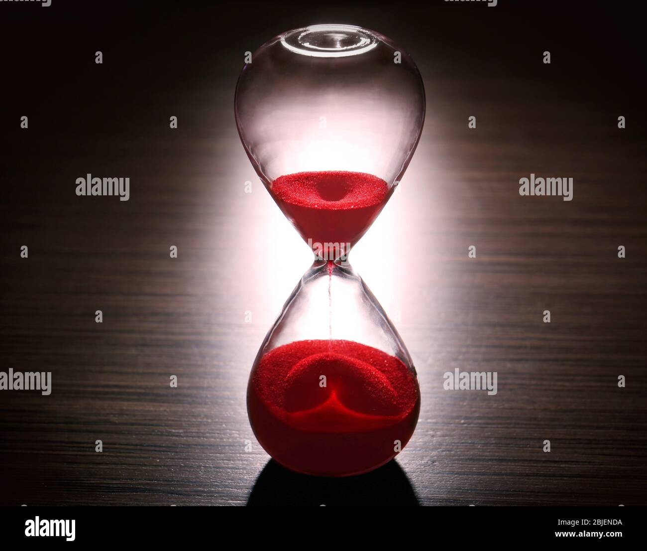 Sablier en cristal avec sable rouge sur fond sombre Photo Stock - Alamy