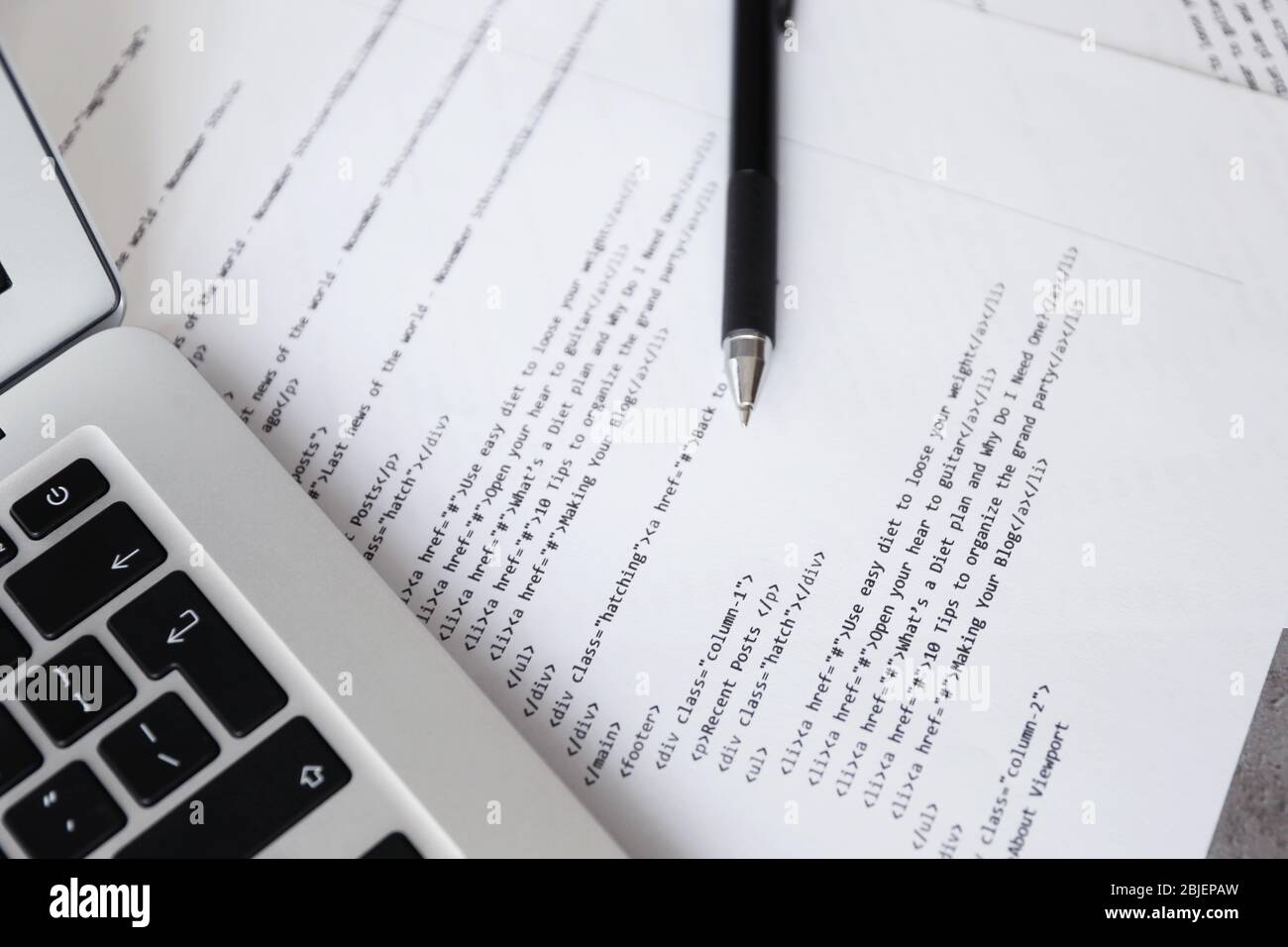 Code de script sur papier, stylo et ordinateur portable sur le lieu de travail du programmeur Banque D'Images