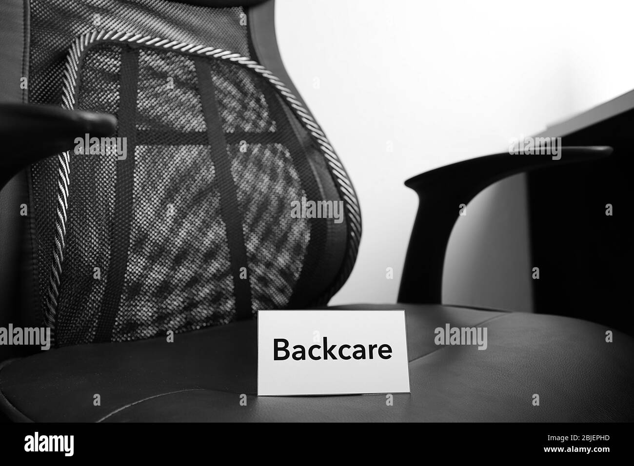 Livre blanc avec mot BACKCARE sur chaise de bureau noire Banque D'Images