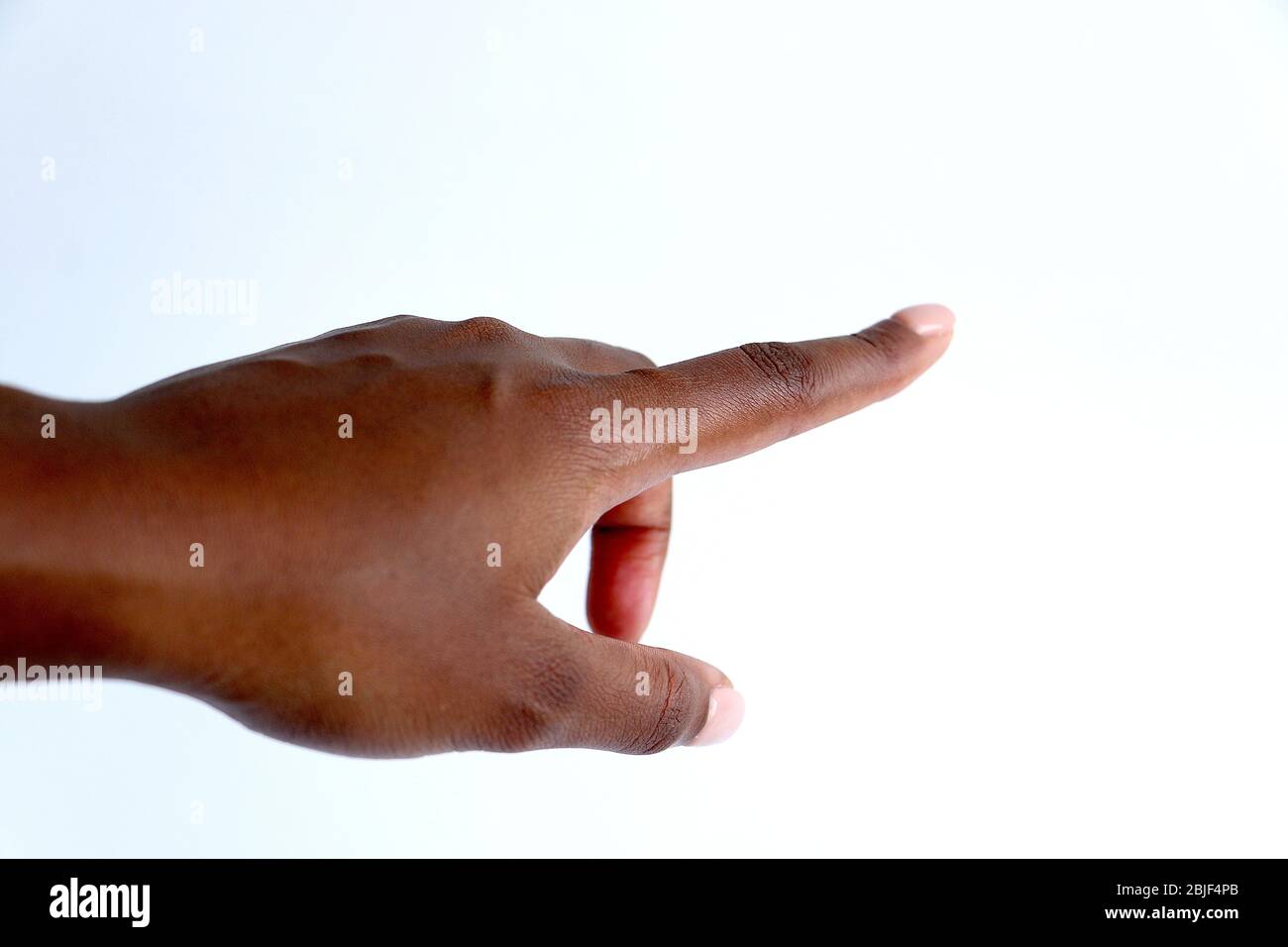 Main femelle isolée et soignée indienne noire africaine, pointant ou appuyant sur le bouton Banque D'Images