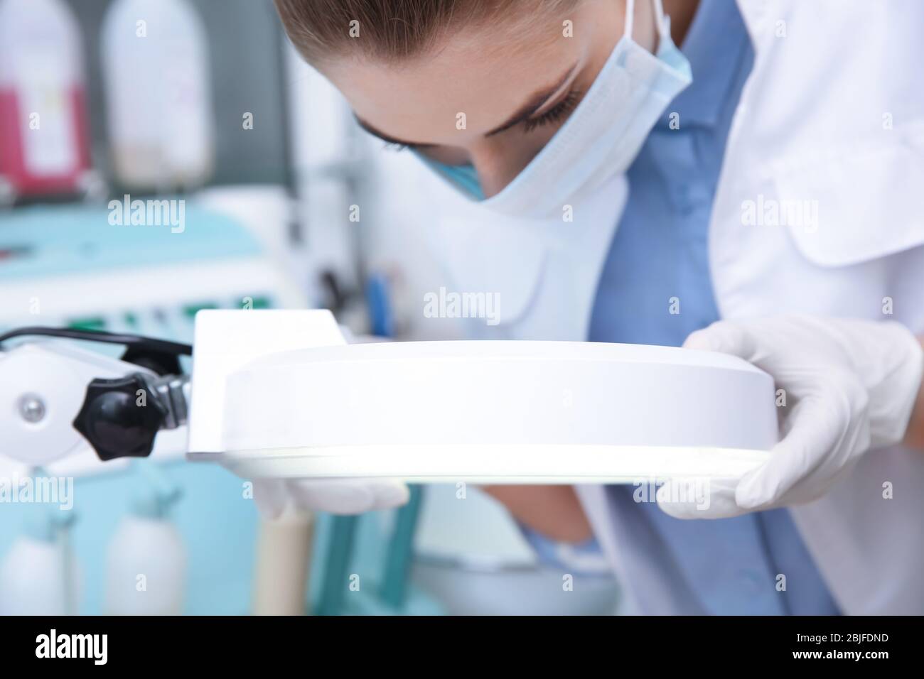 Dermatologue féminine utilisant une lampe grossissante à la clinique Banque D'Images