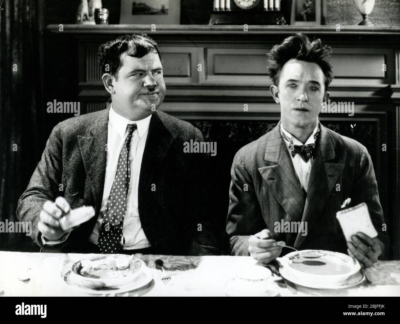 Laurel et Hardy à la table du dîner dans une scène de "You're Darn Tootin", un film classique de comédie de MGM Hollywood silencieux en 1928. Banque D'Images