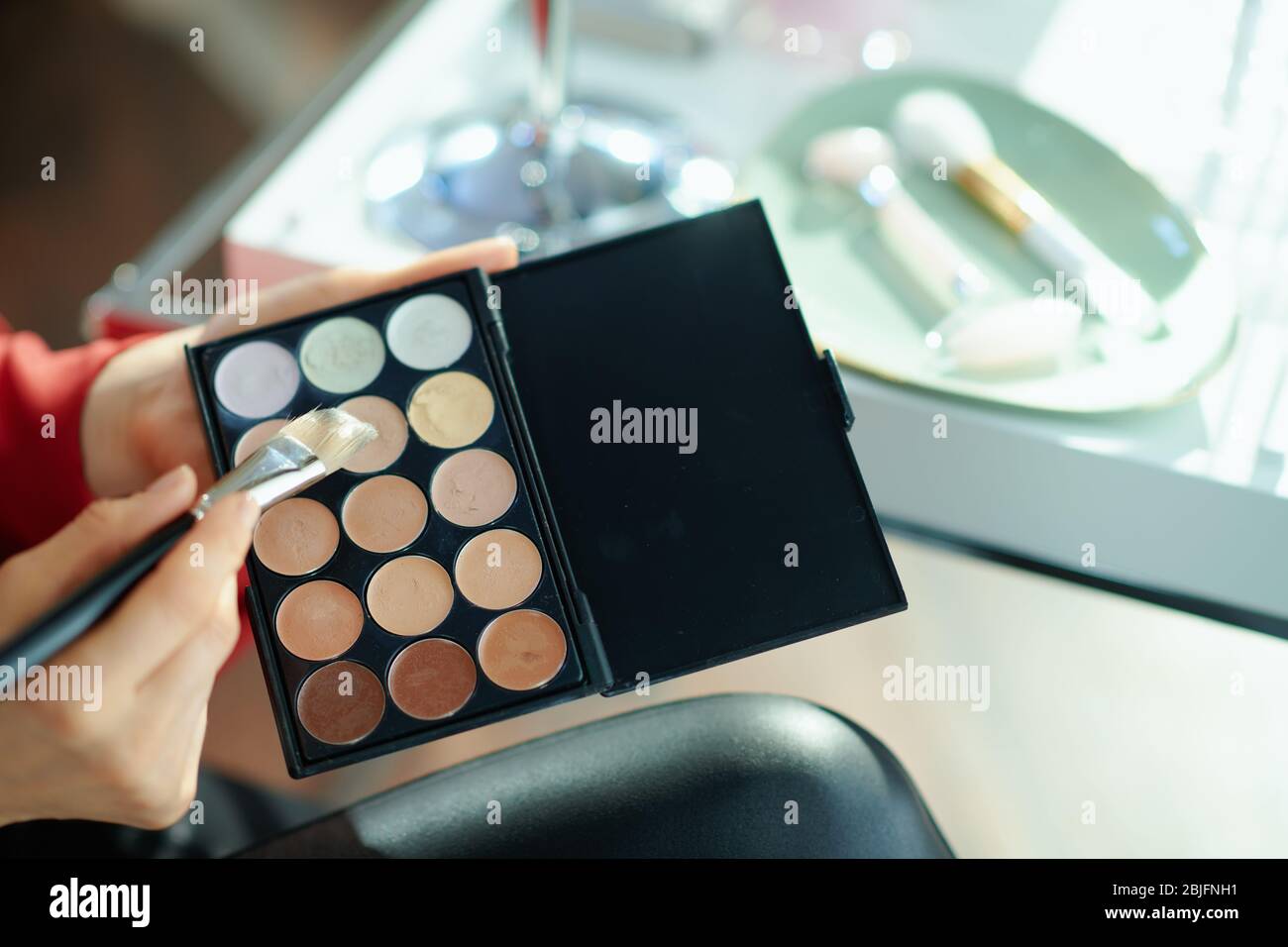 Gros plan sur femme à la maison en journée ensoleillée à l'aide de la palette de cache. Banque D'Images