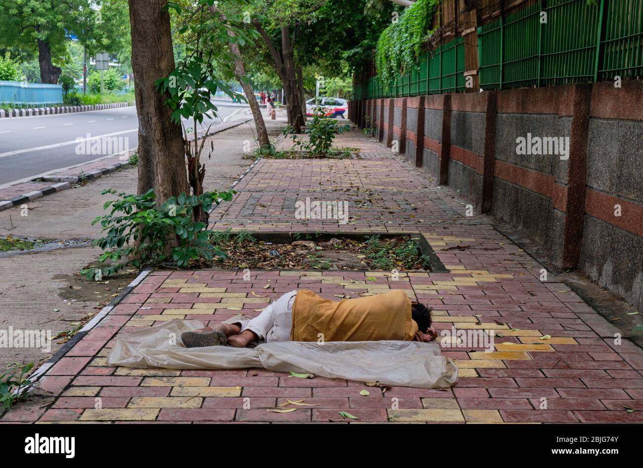 Pauvre homme sans domicile dormant sur le trottoir à New Delhi, en Inde Banque D'Images