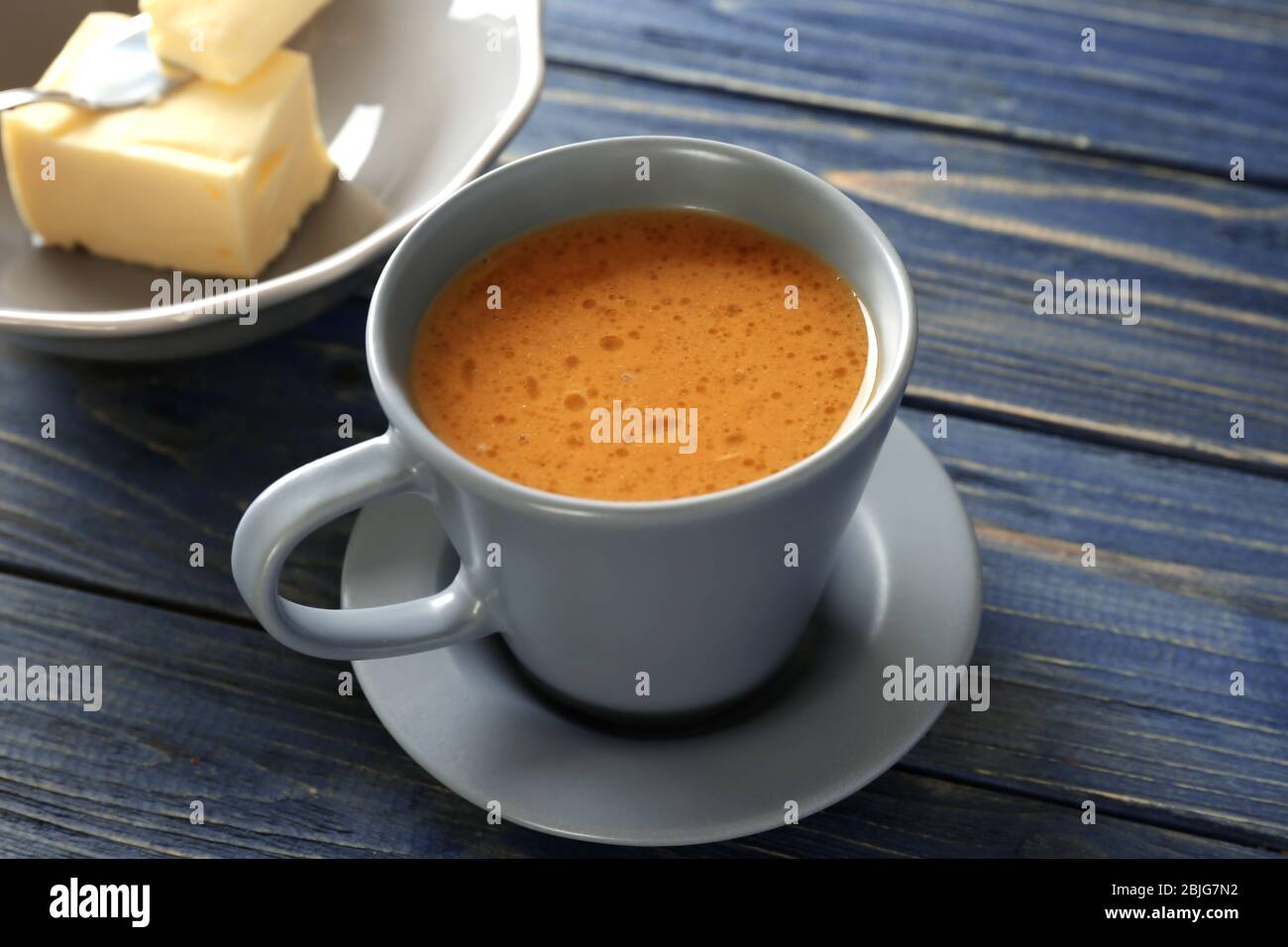 Tasse de café au beurre savoureux sur table en bois Banque D'Images