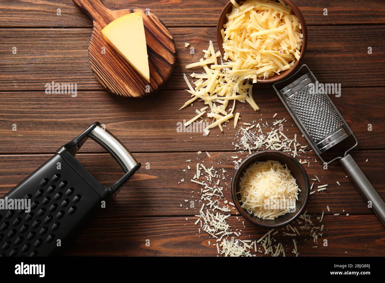 Homme Râper Du Fromage Sur Une Petite Planche De Bois Fromage Râpé Pour La  Cuisson Sur Une Planche à Découper Sur Un Fond En Bois