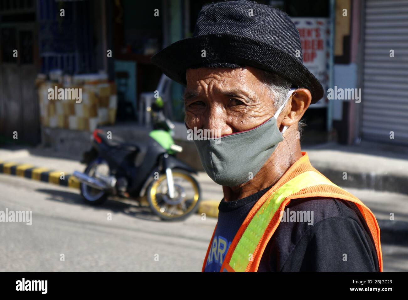 Antipolo City, Philippines - 28 avril 2020: Homme philippin adulte portant un tissu ou un masque de visage lavable et un chapeau comme protection pendant le virus Covid 19 Banque D'Images