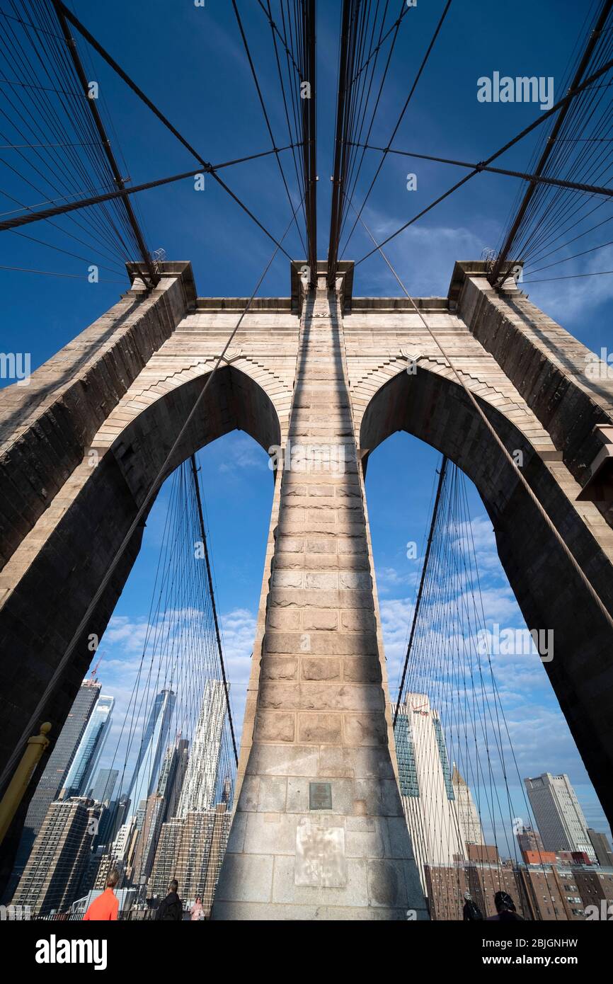 Vue abstraite grand angle regardant la tour voûtée gothique tenant le pont de Brooklyn avec des détails de câble traversant Banque D'Images