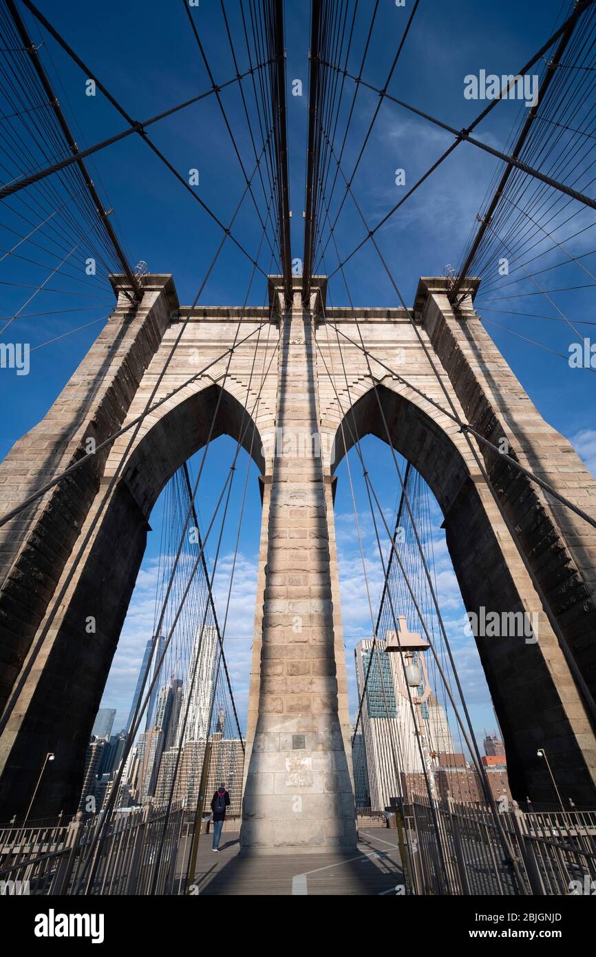 Vue abstraite grand angle regardant la tour voûtée gothique tenant le pont de Brooklyn avec des détails de câble traversant Banque D'Images
