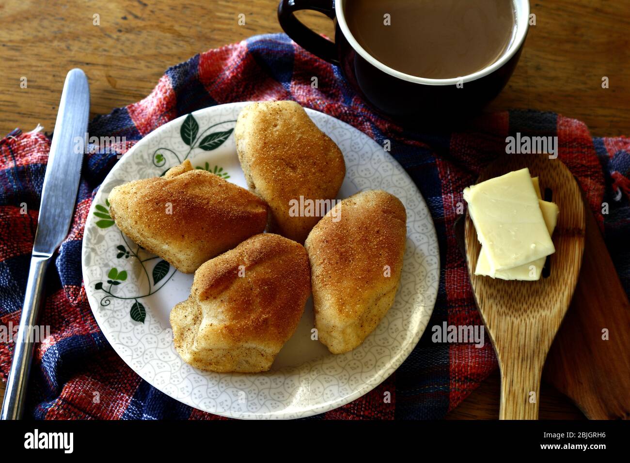 Photo de pain philippin fraîchement cuit appelé Pan de sal ou pain de sel, café et tranches de fromage sur une table. Banque D'Images