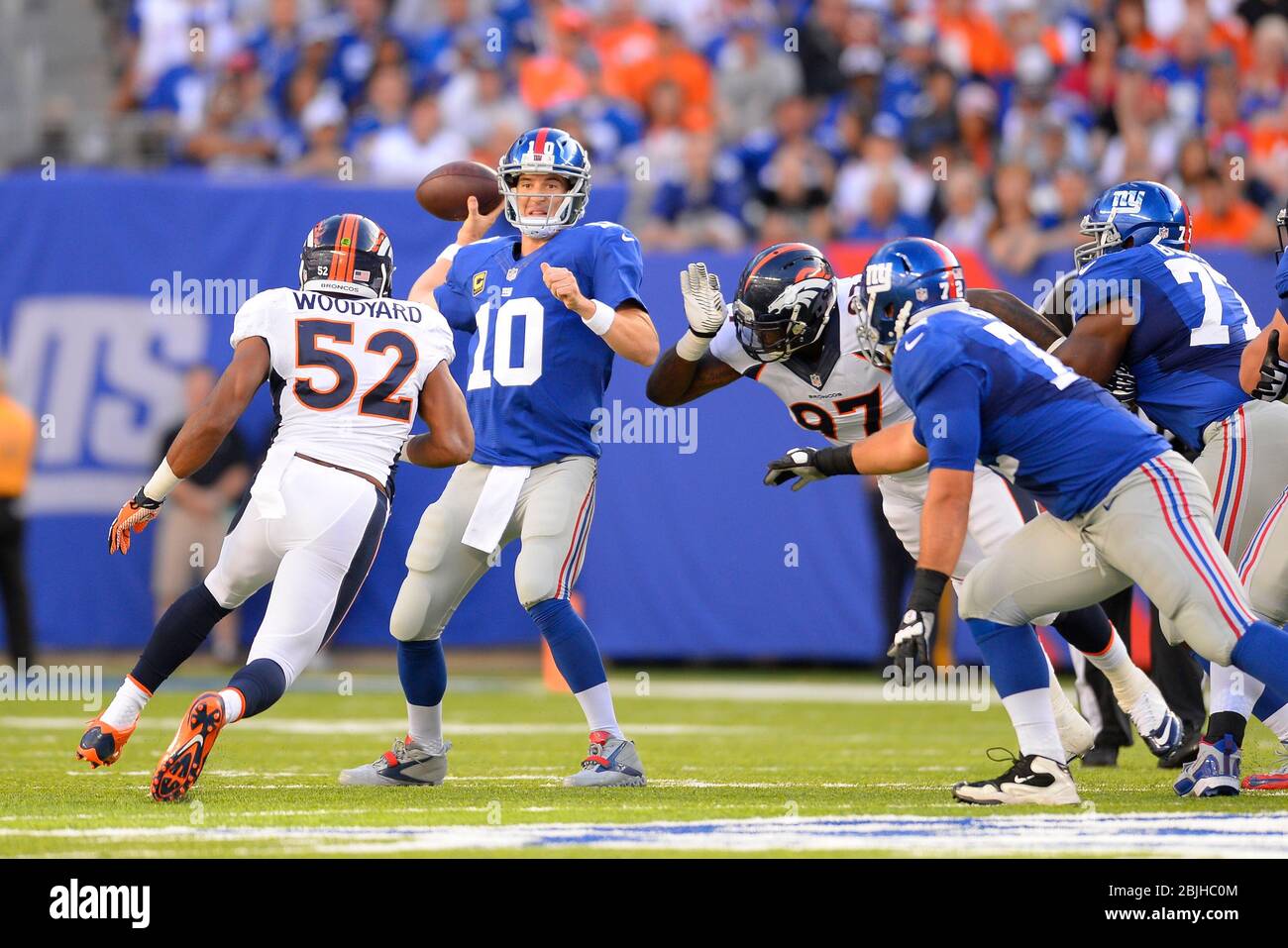 15 septembre 2013 : le quart de carrière de New York Giants Eli Manning (10) est passé dans les rushés par Denver Broncos en dehors de la zone de bois de linebacker Wesley (52) et Denver B Banque D'Images
