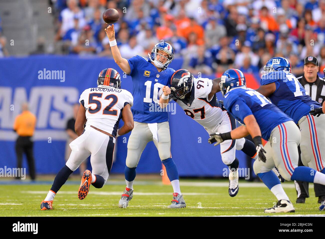 15 septembre 2013 : le quart de carrière de New York Giants Eli Manning (10) est passé dans les rushés par Denver Broncos en dehors de la zone de bois de linebacker Wesley (52) et Denver B Banque D'Images