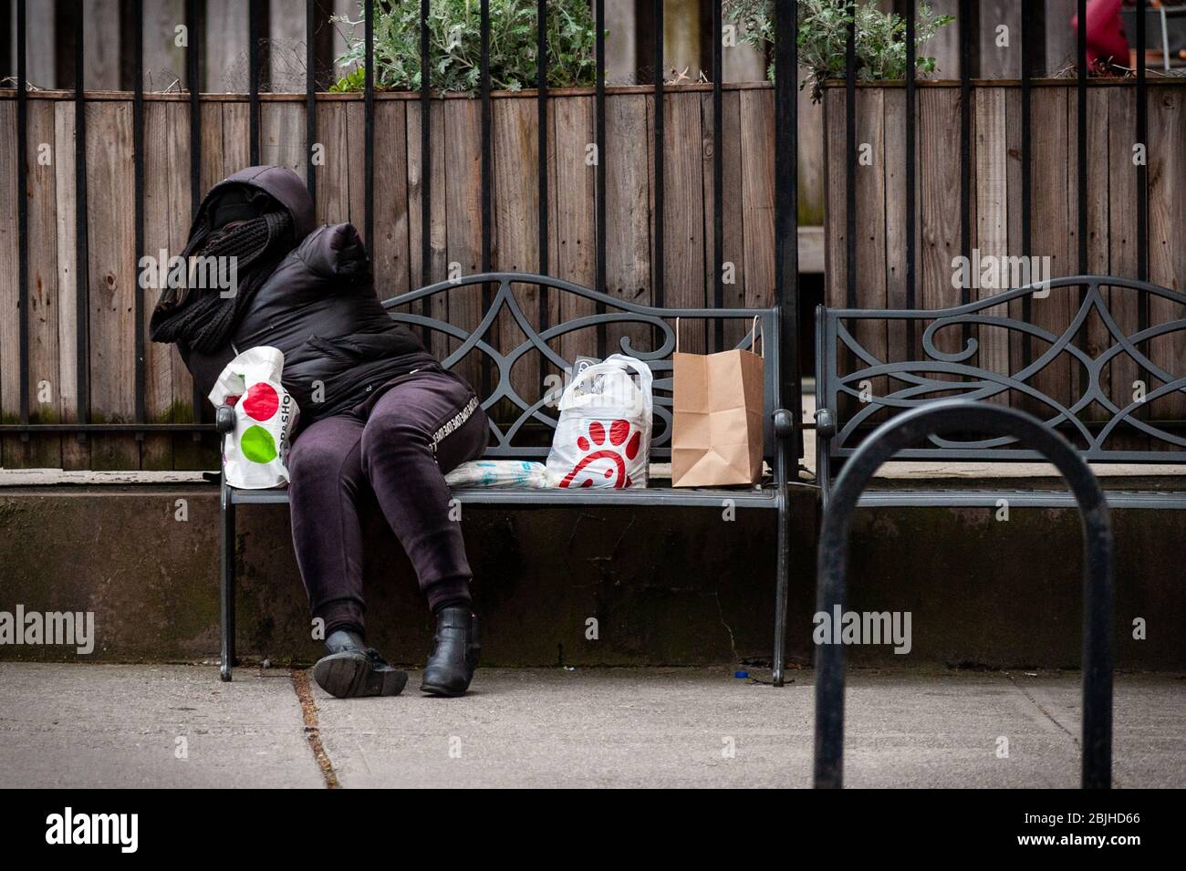 Brooklyn, États-Unis d'Amérique . 29 avril 2020. Une personne sans abri repose sur un banc de parc dans le quartier de Park Slope à Brooklyn le 29 avril 2020. La pandémie de COVID-19 a frappé la population non protégée particulièrement durement et met en lumière la crise des sans-abri à New York, qui est la plus élevée depuis la Grande dépression. (Photo de Gabriele Holtermann-Gorden/Sipa USA) crédit: SIPA USA/Alay Live News Banque D'Images