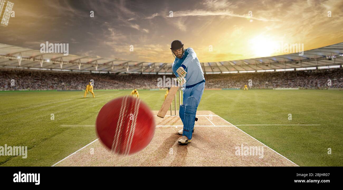 Jeune sportif qui frappe le ballon tout en se battant dans le terrain de cricket Banque D'Images