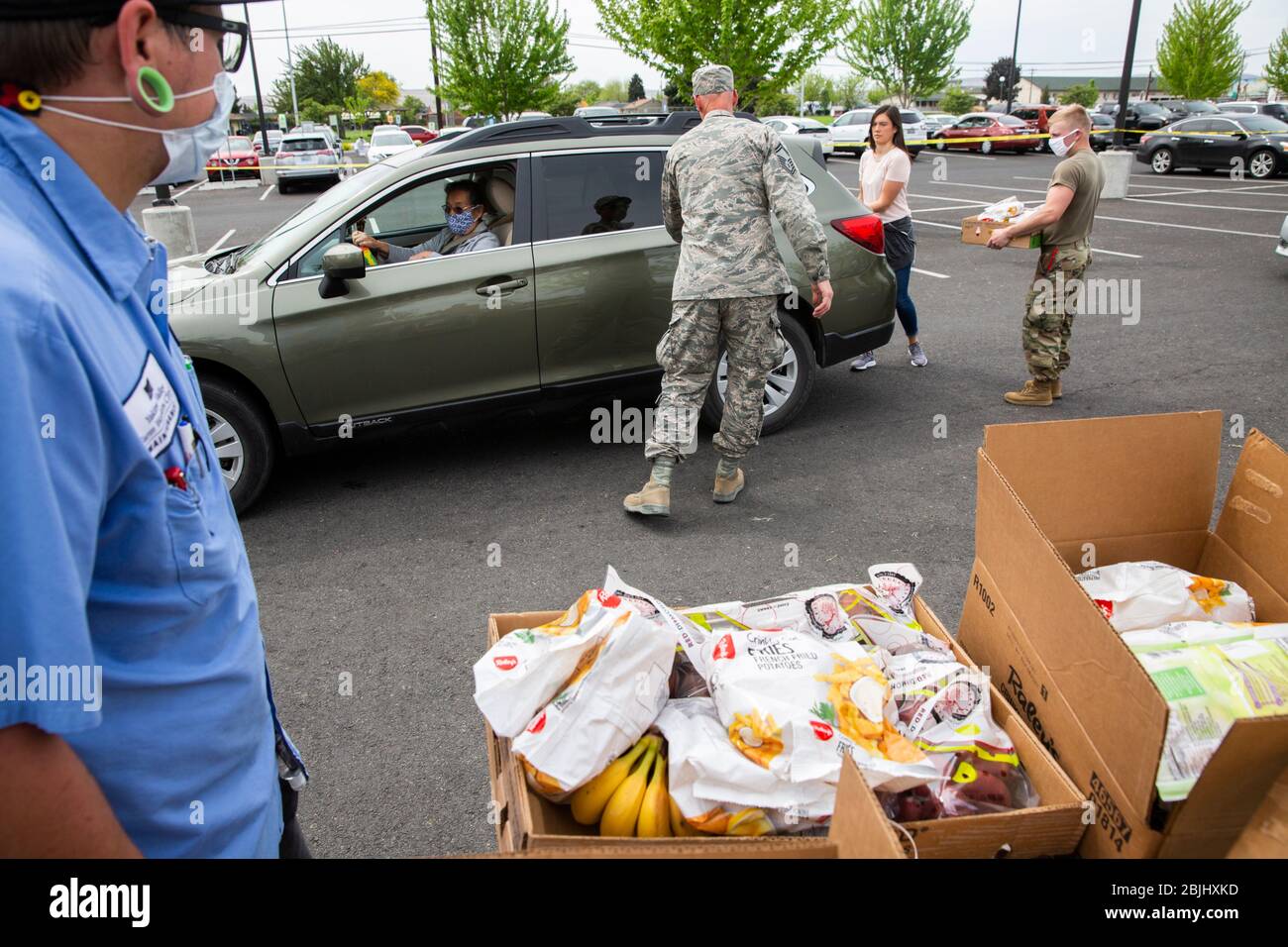 Les employés de la clinique des travailleurs agricoles de la vallée de Yakima et les soldats de la Garde nationale de Washington distribuent des boîtes de nourriture gratuite aux résidents sous des impos de l'État Banque D'Images
