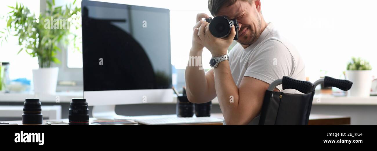 Le photographe handicapé masculin tient l'appareil photo dans ses mains Banque D'Images