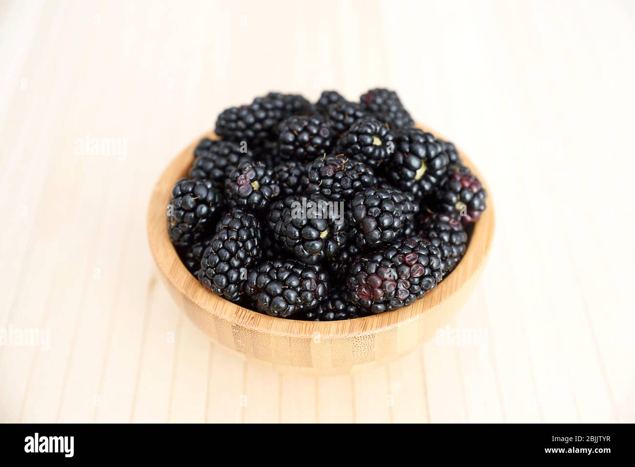 Plein de BlackBerry dans le bol en bois sur la table en bois. Banque D'Images