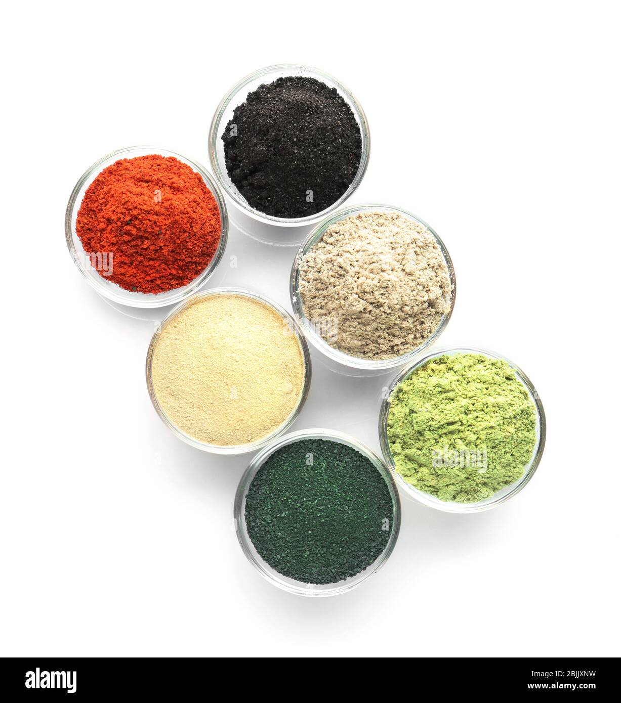 Différentes poudres supraalimentaires colorées dans des bols sur fond blanc Banque D'Images