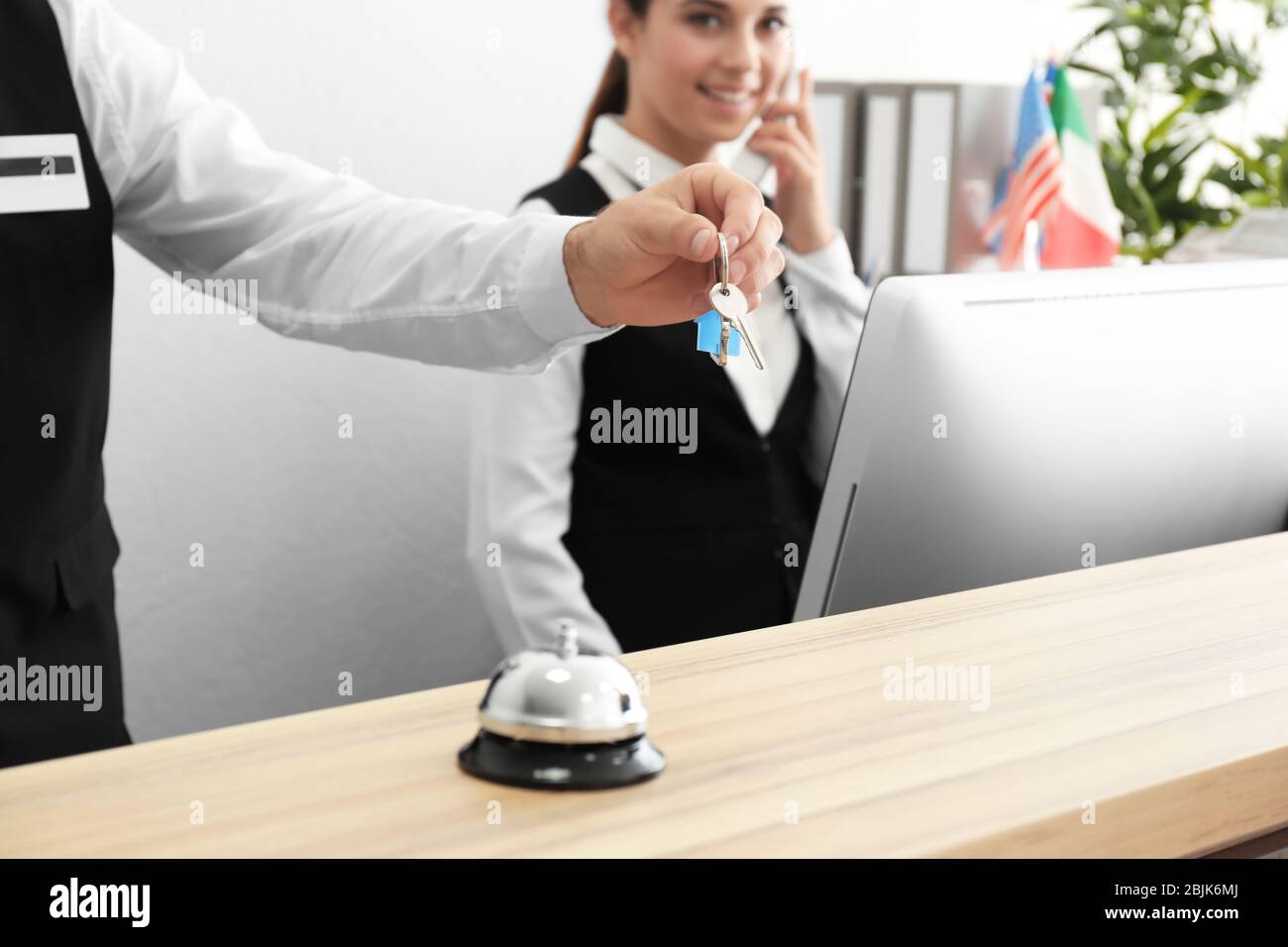 Main de réceptionniste avec clé de chambre dans l'hôtel Banque D'Images