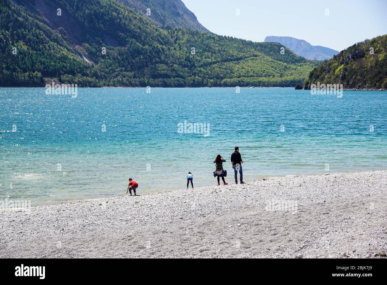 Une famille heureuse avec des enfants ayant les vacances d'été au lac avec plage Banque D'Images