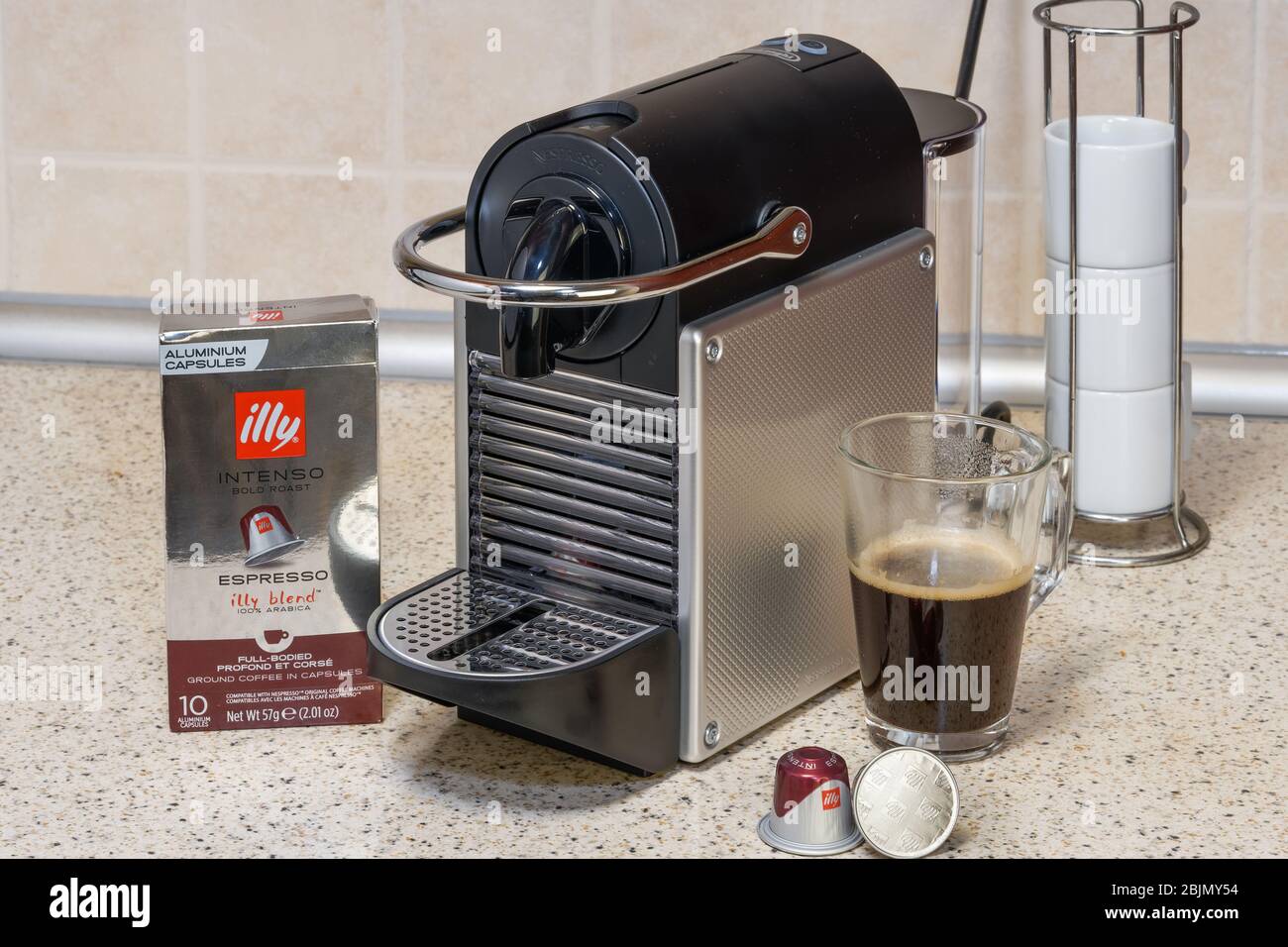 Machine Nespresso automatique utilisée pour créer un espresso avec capsules  en aluminium. Dosettes en métal Illy autour de la cafetière, pour préparer  du café chaud Photo Stock - Alamy