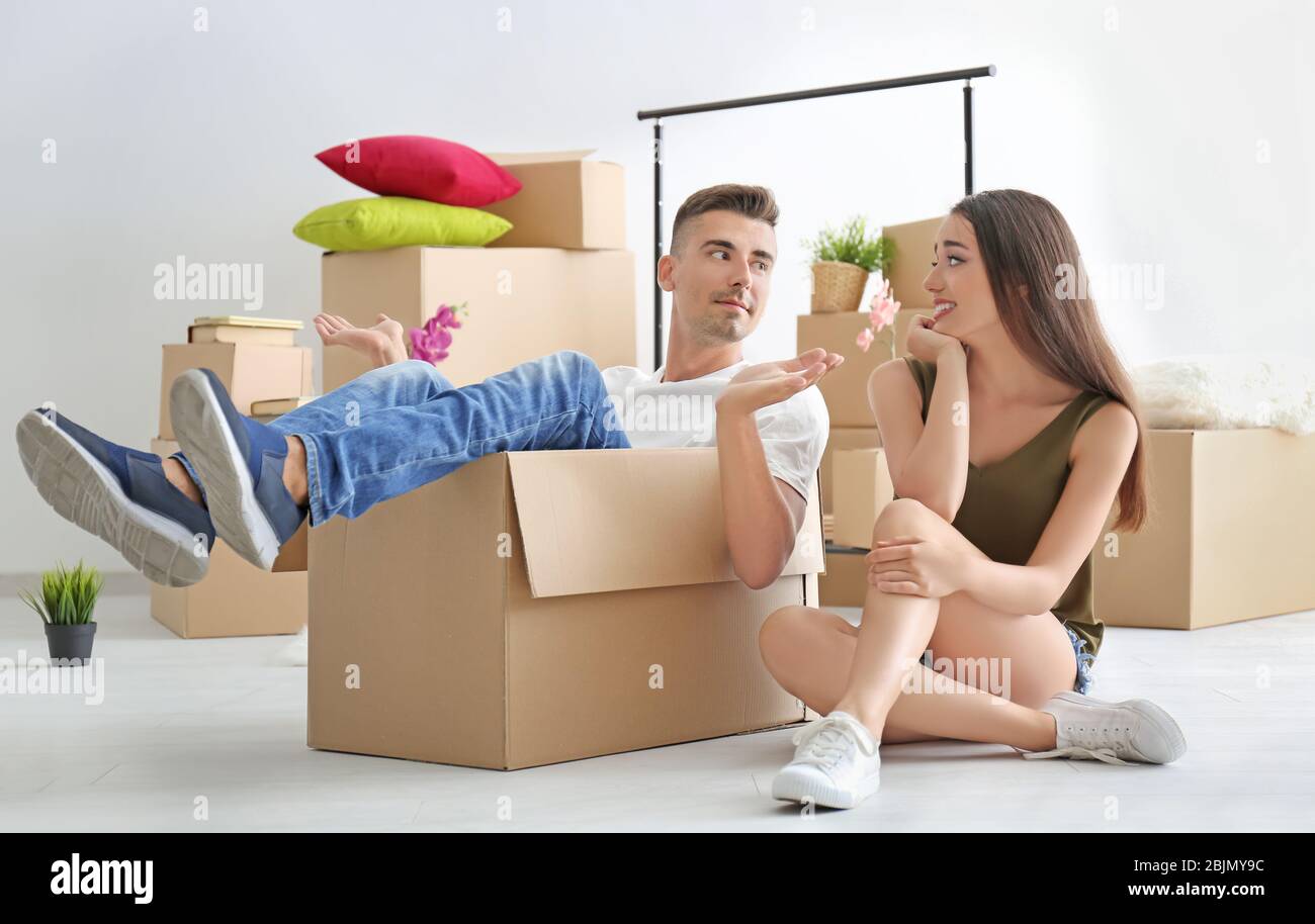 Jeune couple heureux s'amuser tout en s'emballant dans la chambre Banque D'Images