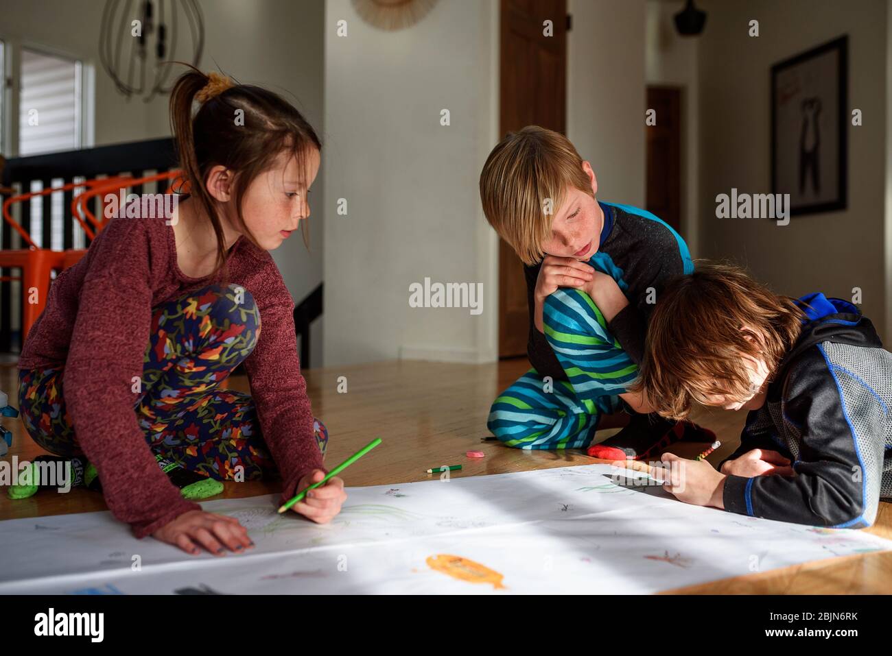 Trois jeunes enfants travaillant sur un projet artistique à la maison Banque D'Images