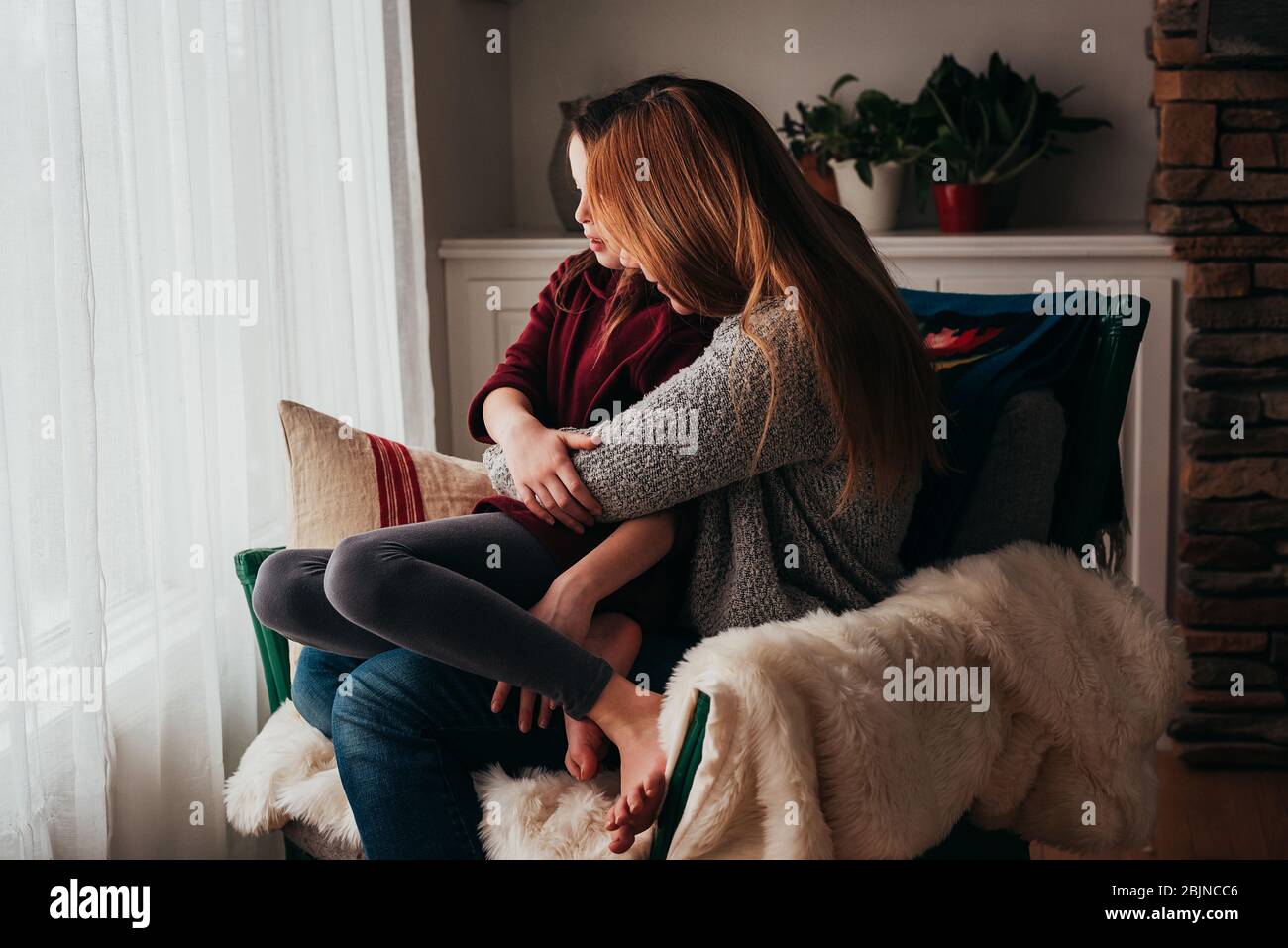 Mère et fille se couchant dans un fauteuil Banque D'Images