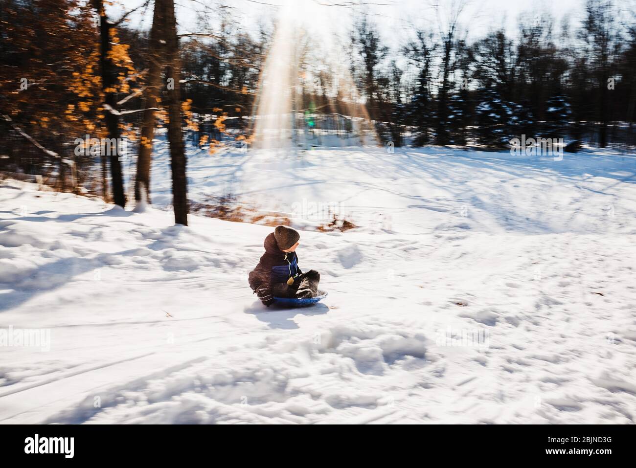 Garçon en traîneau à une colline dans la neige, États-Unis Banque D'Images