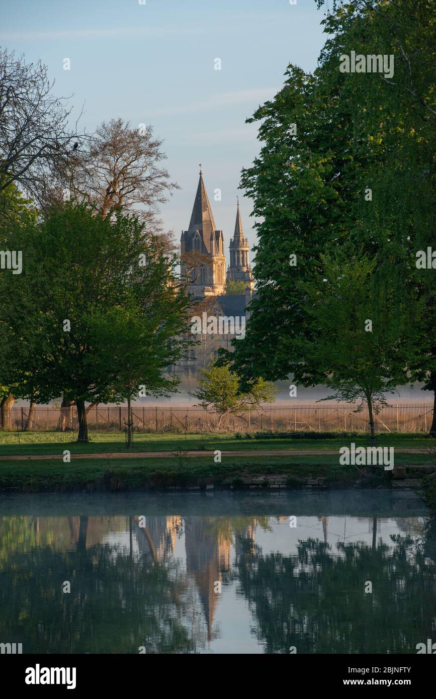 Vue sur l'Isis, tôt le matin, en regardant vers le Christ Church College, avec la spire de l'ancienne église Saint-Michaels (maintenant bibliothèque du Lincoln College) Banque D'Images