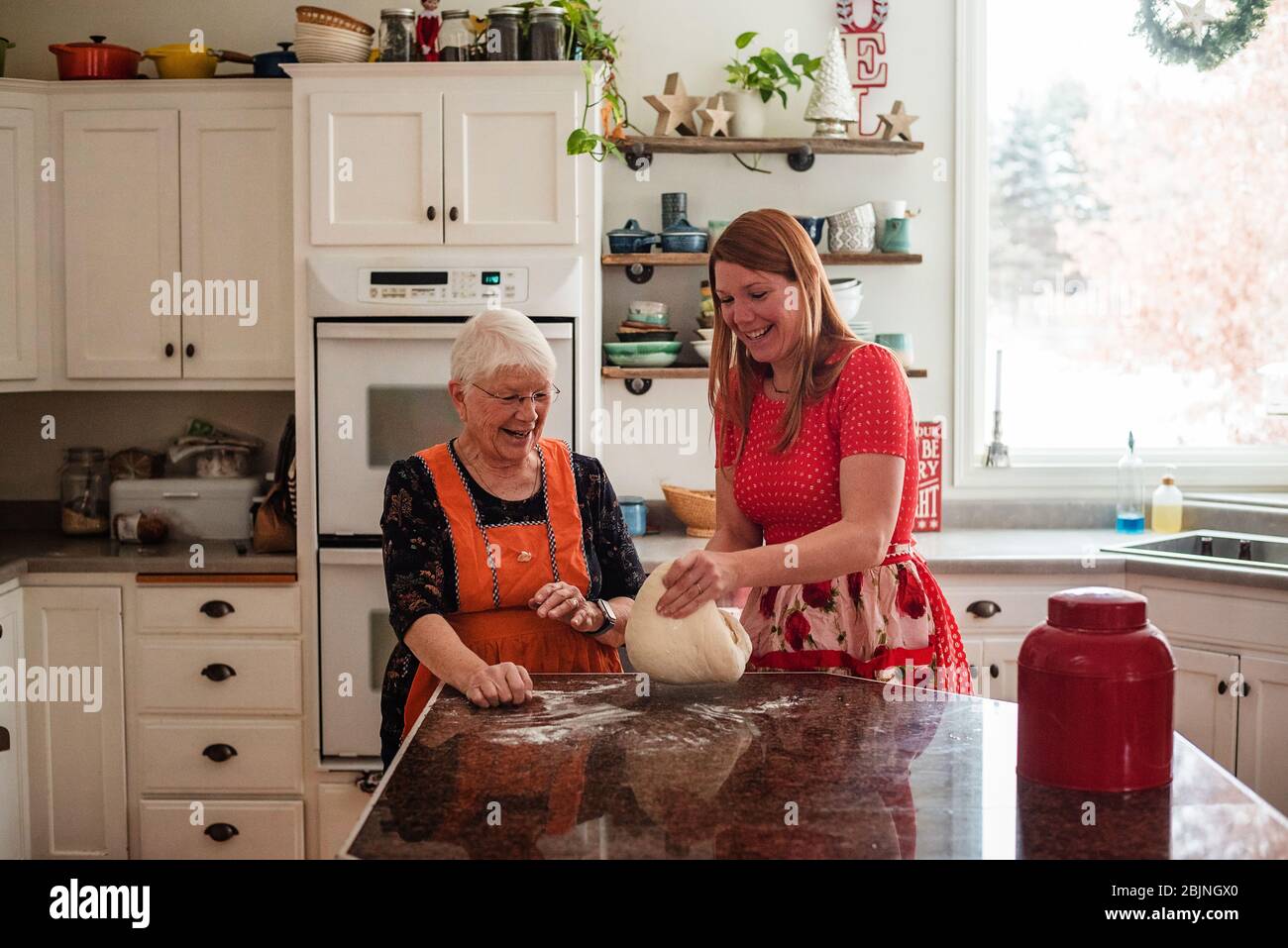 Femme âgée enseignant à sa fille de faire du pain Banque D'Images
