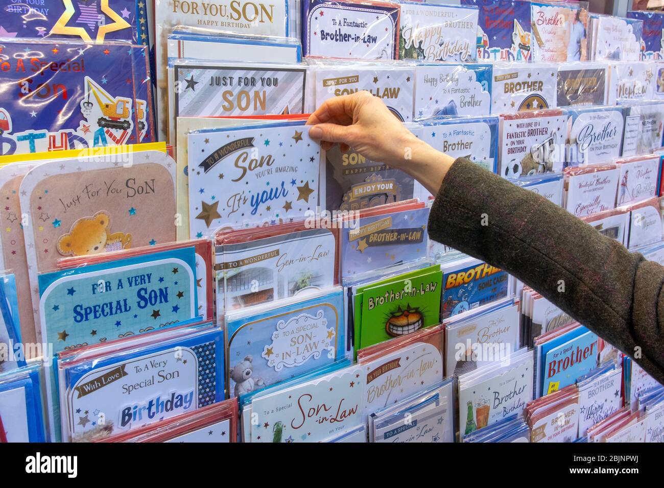 Personne qui chosing une carte de voeux dans une boutique de cartes. ROYAUME-UNI. Banque D'Images