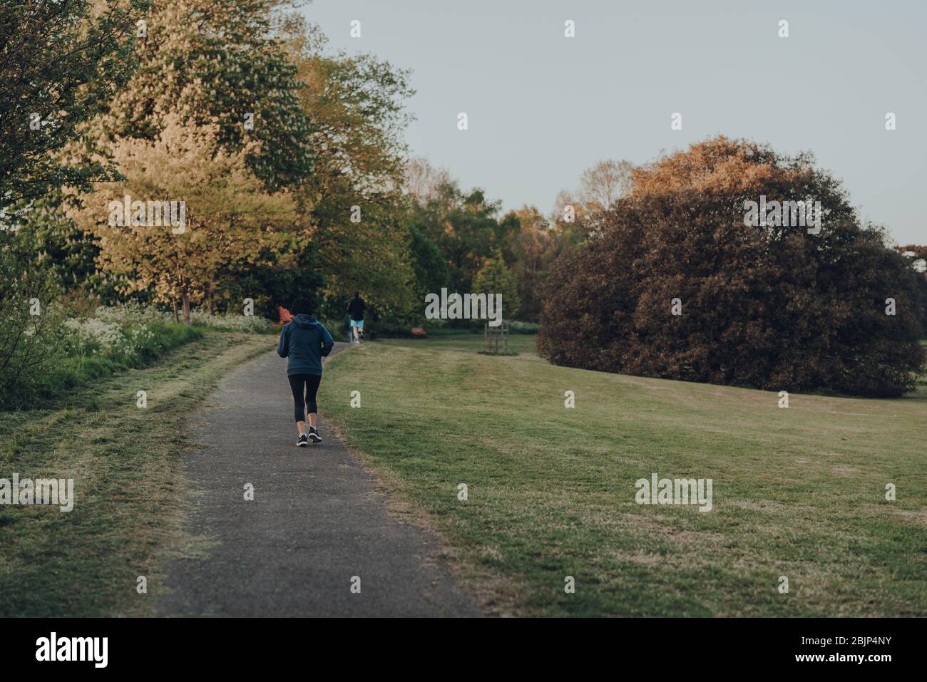 Londres, Royaume-Uni - 22 mars 2020: Vue arrière des personnes qui se trouvent à Broomfield Park, parc public à Palmers Green dans le quartier londonien d'Enfield, Royaume-Uni. Banque D'Images