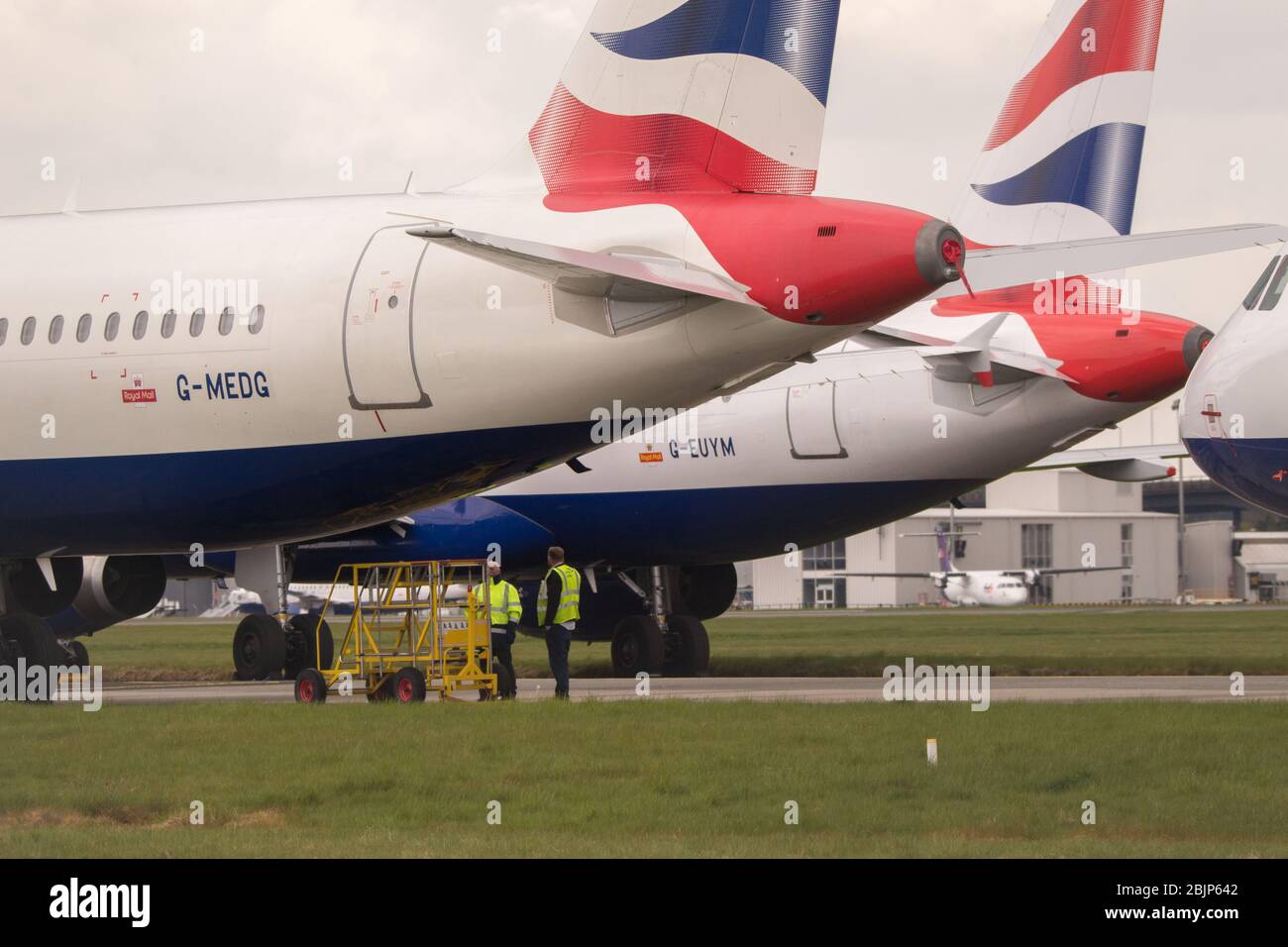 Glasgow, Royaume-Uni. 30 avril 2020. Photo : les nuages de tempête se rassemblent alors que les équipes au sol de British Airways assurent la collecte de 14 appareils Airbus A 319/A 320 et A 321 mis à la terre qui ont été stationnés sur la deuxième piste de l'aéroport de Glasgow depuis le début du verrouillage du Coronavirus (COVID-19). Depuis, l'industrie mondiale des compagnies aériennes est en train de s'effondrer, certaines compagnies aériennes ayant fait faillite et d'autres comme BA demandant une aide financière du gouvernement. A ce jour, BA a annoncé qu'elle axait près de 12 000 employés. Crédit : Colin Fisher/Alay Live News Banque D'Images