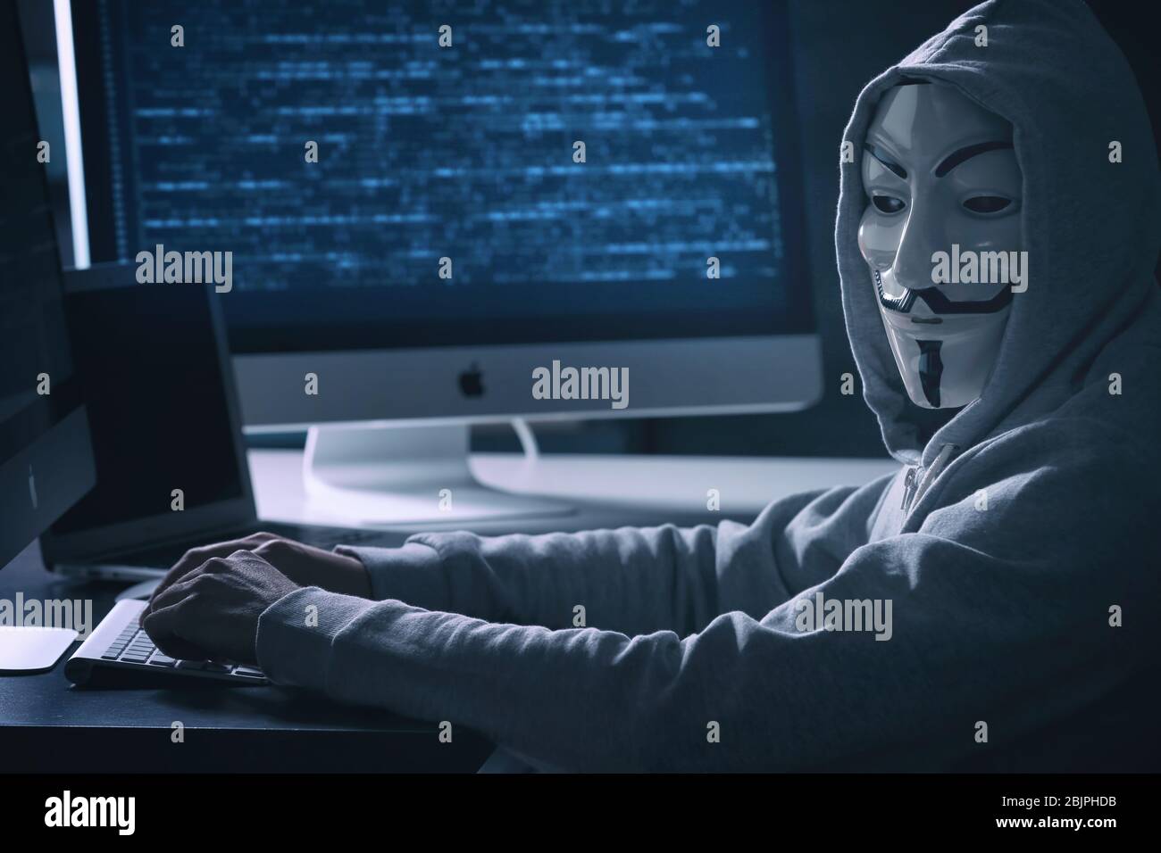 MYKOLAIV, UKRAINE - 29 SEPTEMBRE 2017: Personne anonyme dans le masque Guy Fawkes utilisant l'ordinateur à l'intérieur Banque D'Images