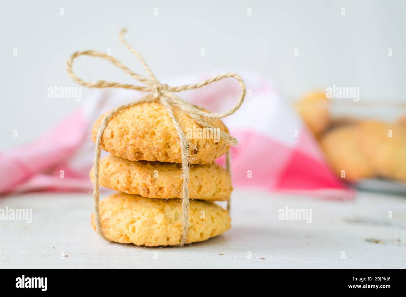 Cookies maison à la noix de coco sur table en bois blanc. Biscuits de noix de coco fraîchement cuits sur fond rustique. Cookies présents. Mise au point sélective. Banque D'Images