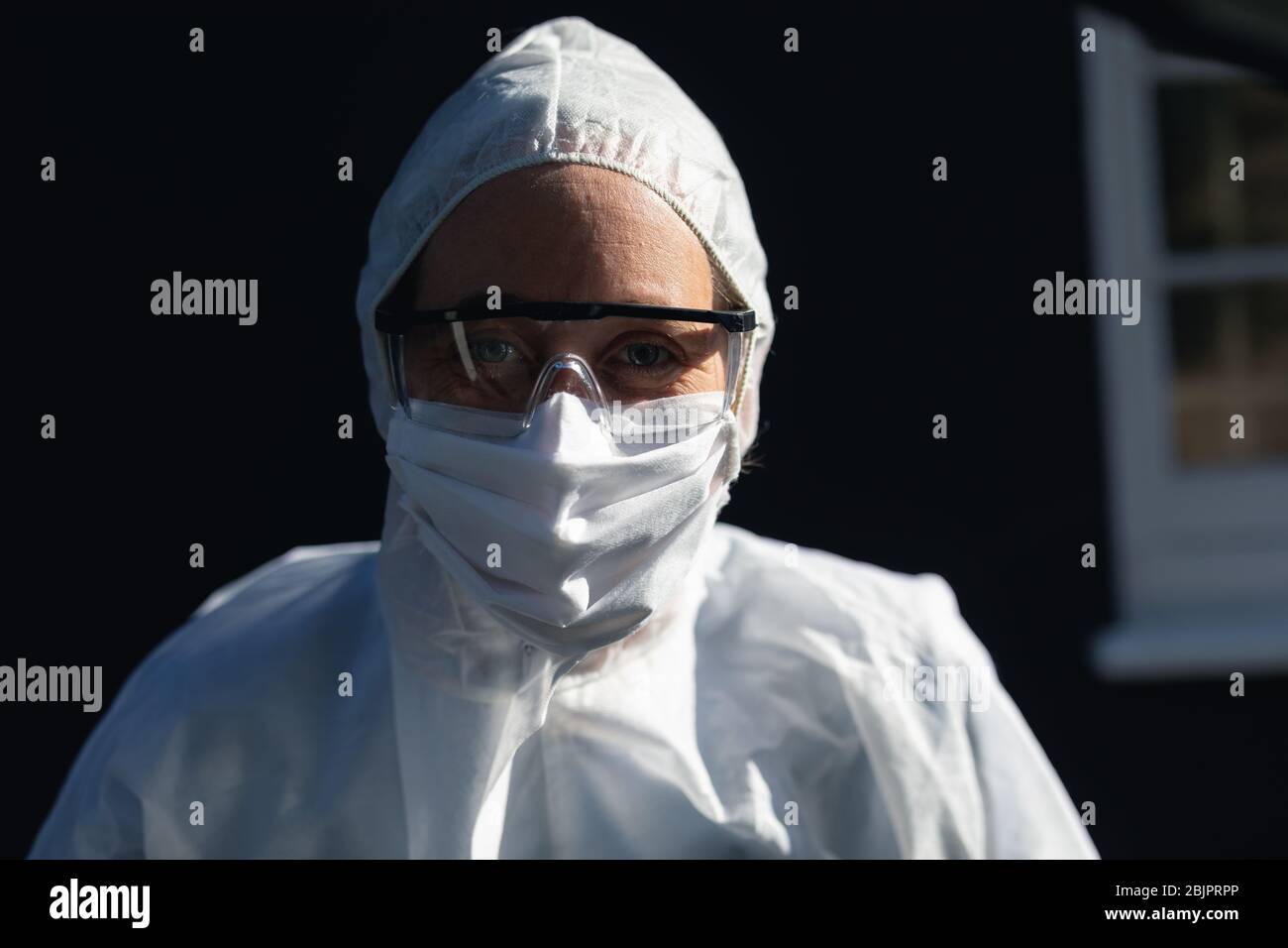 Femme caucasienne portant des combinaisons de laboratoire et des extdide masque de covid19 coronvirus Banque D'Images
