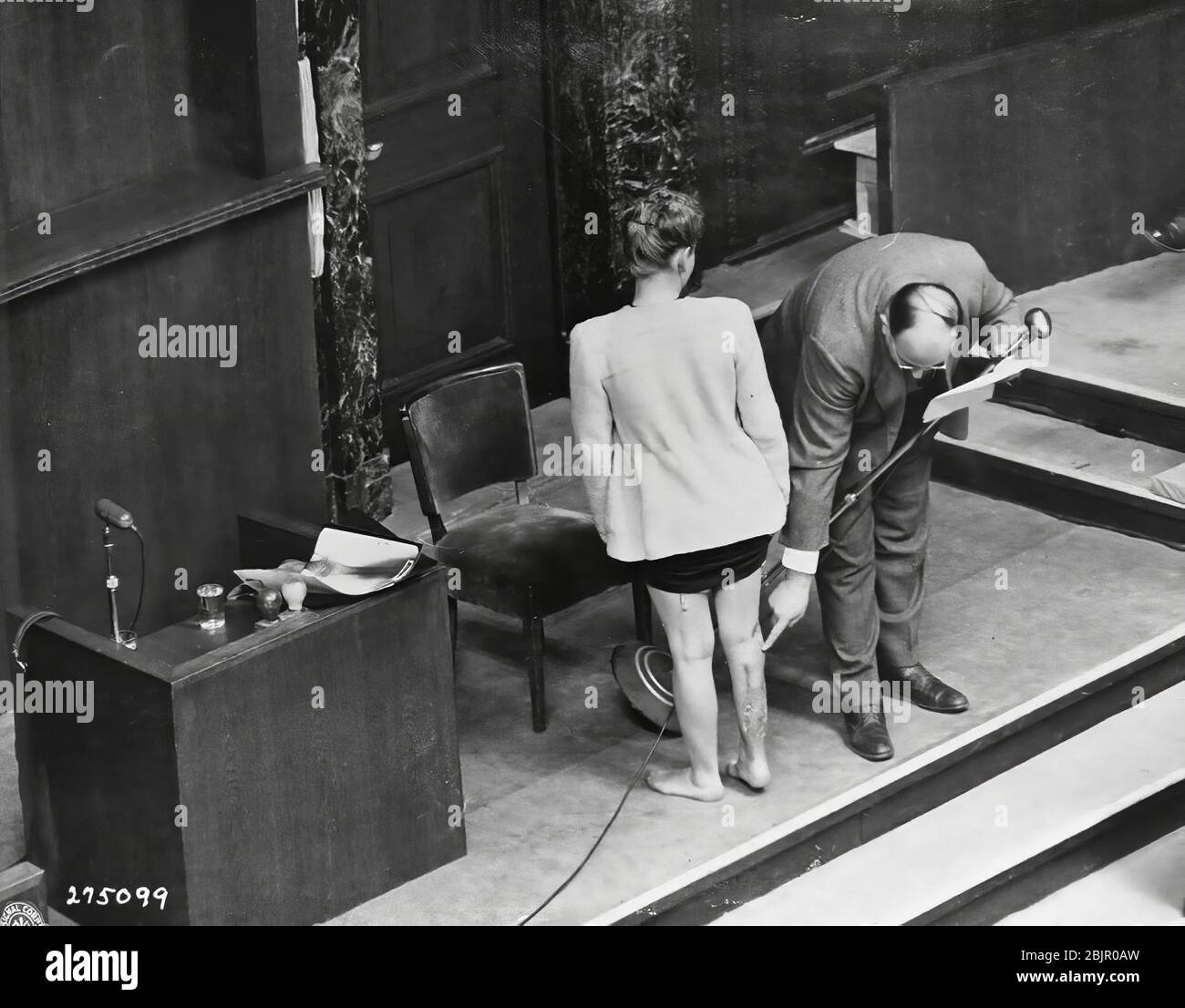 Survivant des camps de concentration Jadwiga Dzido montre sa jambe meurtrie au tribunal de Nuremberg, bien qu'expert médical explique la nature des procédures infligées à son RavensbrŸck dans le camp de concentration, le 22 novembre 1942. Photo prise le 20 décembre 1946. Banque D'Images