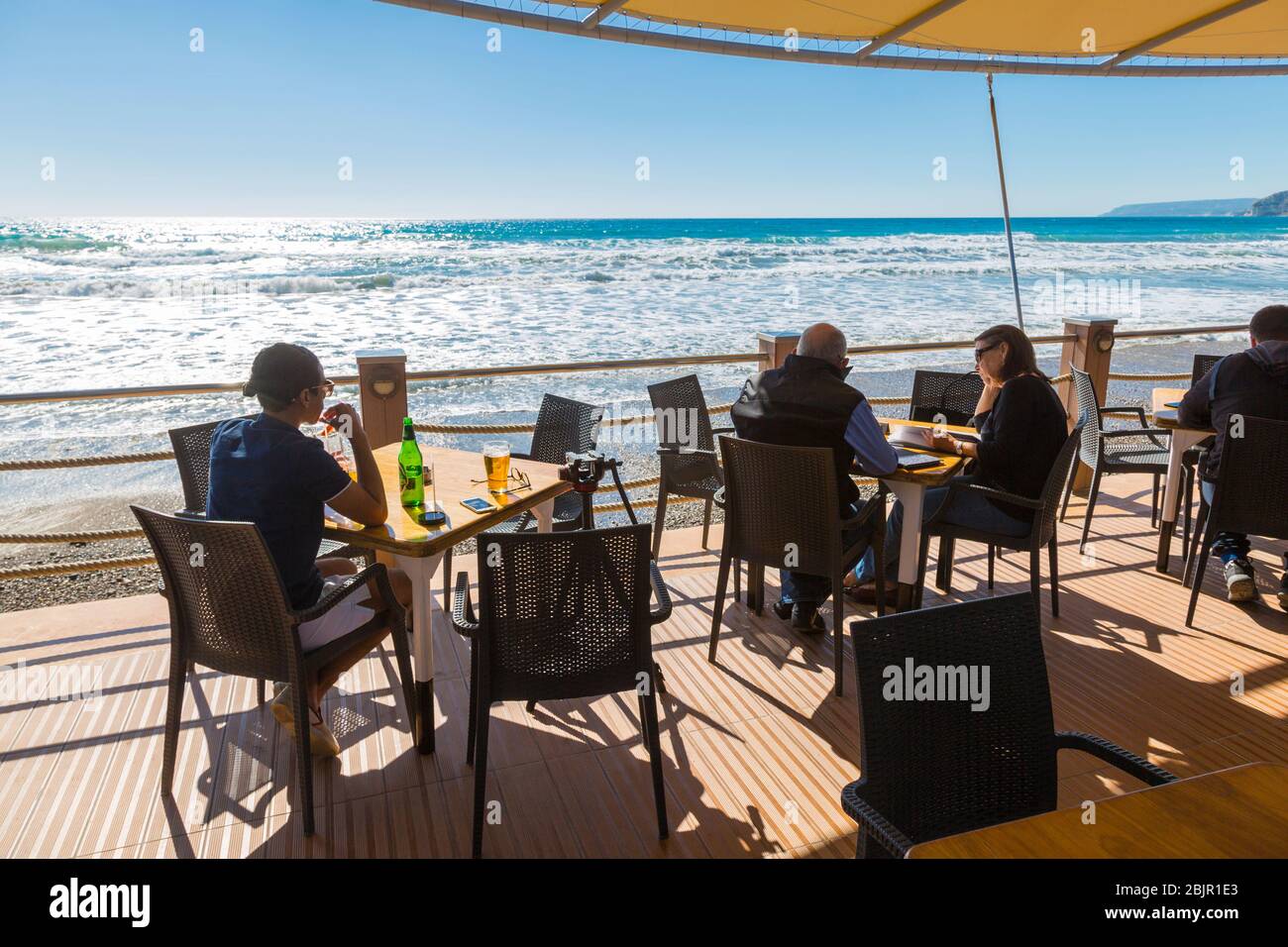 Les touristes dînant et buvant au restaurant Chris Blue Beach de Curium Beach, Limassol, Chypre Banque D'Images