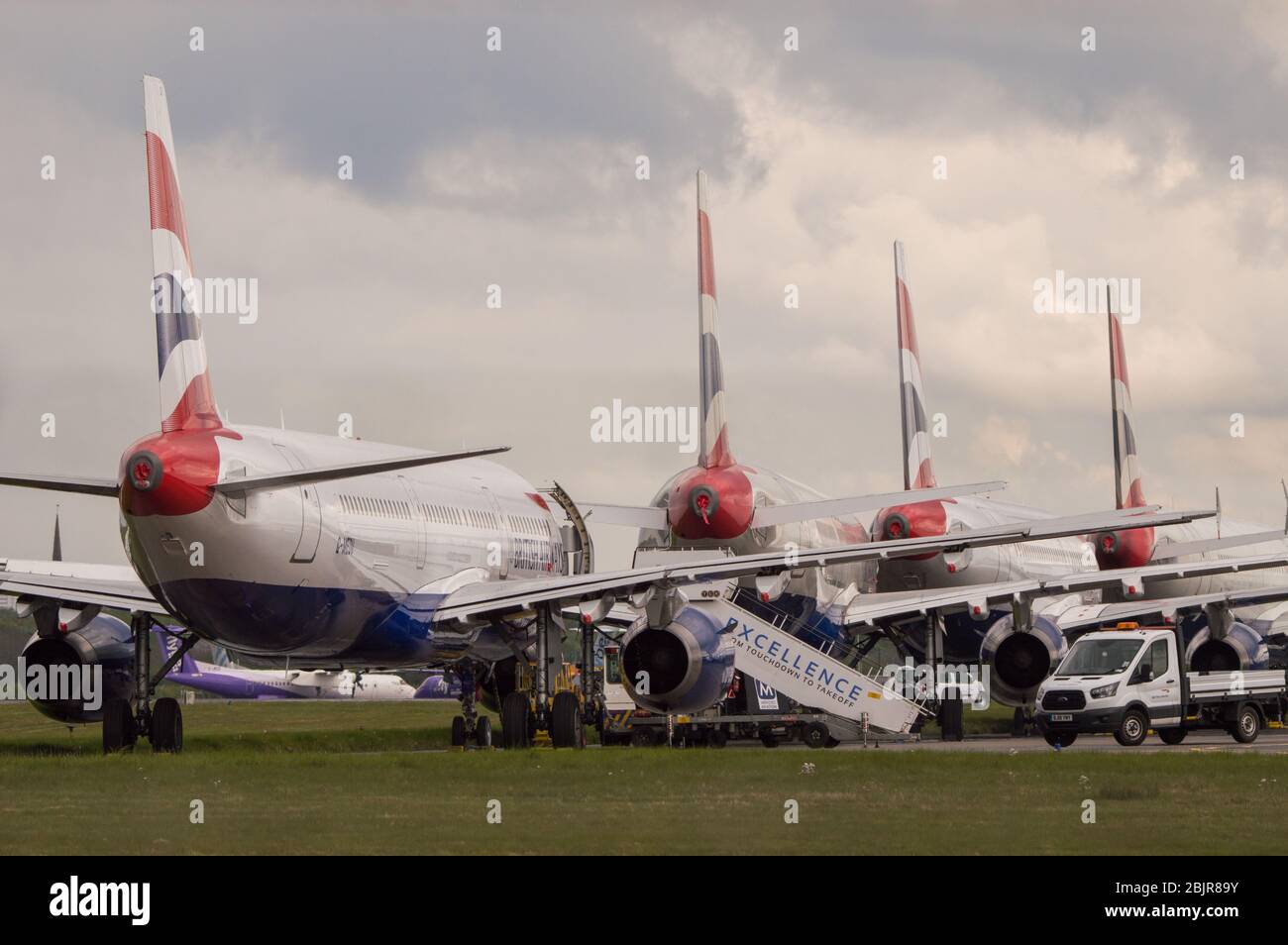 Glasgow, Royaume-Uni. 30 avril 2020. Photo : les nuages de tempête se rassemblent alors que les équipes au sol de British Airways assurent la collecte de 14 appareils Airbus A 319/A 320 et A 321 mis à la terre qui ont été stationnés sur la deuxième piste de l'aéroport de Glasgow depuis le début du verrouillage du Coronavirus (COVID-19). Depuis, l'industrie mondiale des compagnies aériennes est en train de s'effondrer, certaines compagnies aériennes ayant fait faillite et d'autres comme BA demandant une aide financière du gouvernement. A ce jour, BA a annoncé qu'elle axait près de 12 000 employés. Crédit : Colin Fisher/Alay Live News Banque D'Images