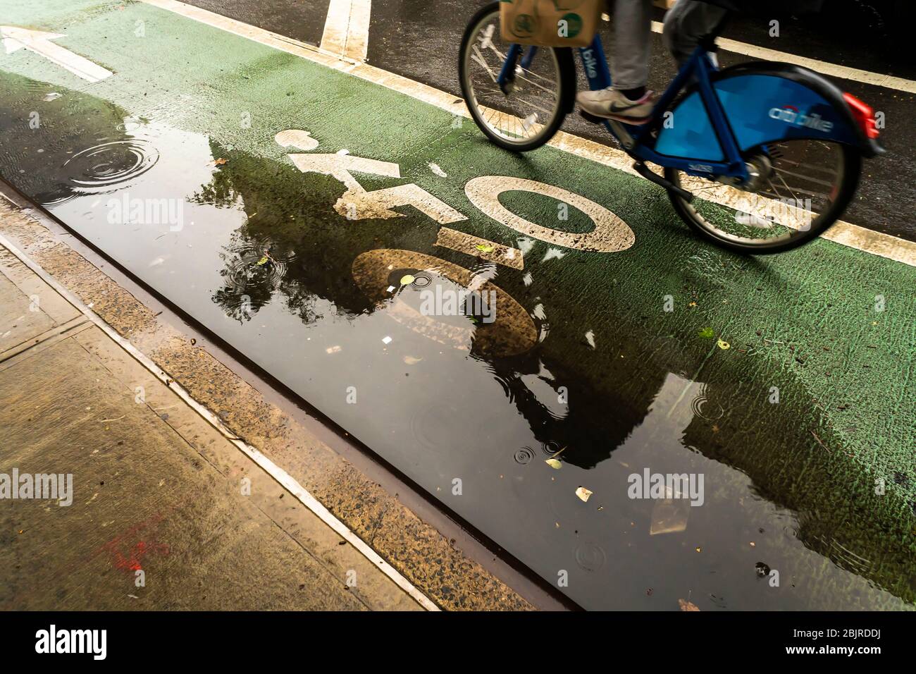 Une flaque dans une piste cyclable sous la pluie dans le quartier Chelsea de New York le dimanche 26 avril 2020. (© Richard B. Levine) Banque D'Images