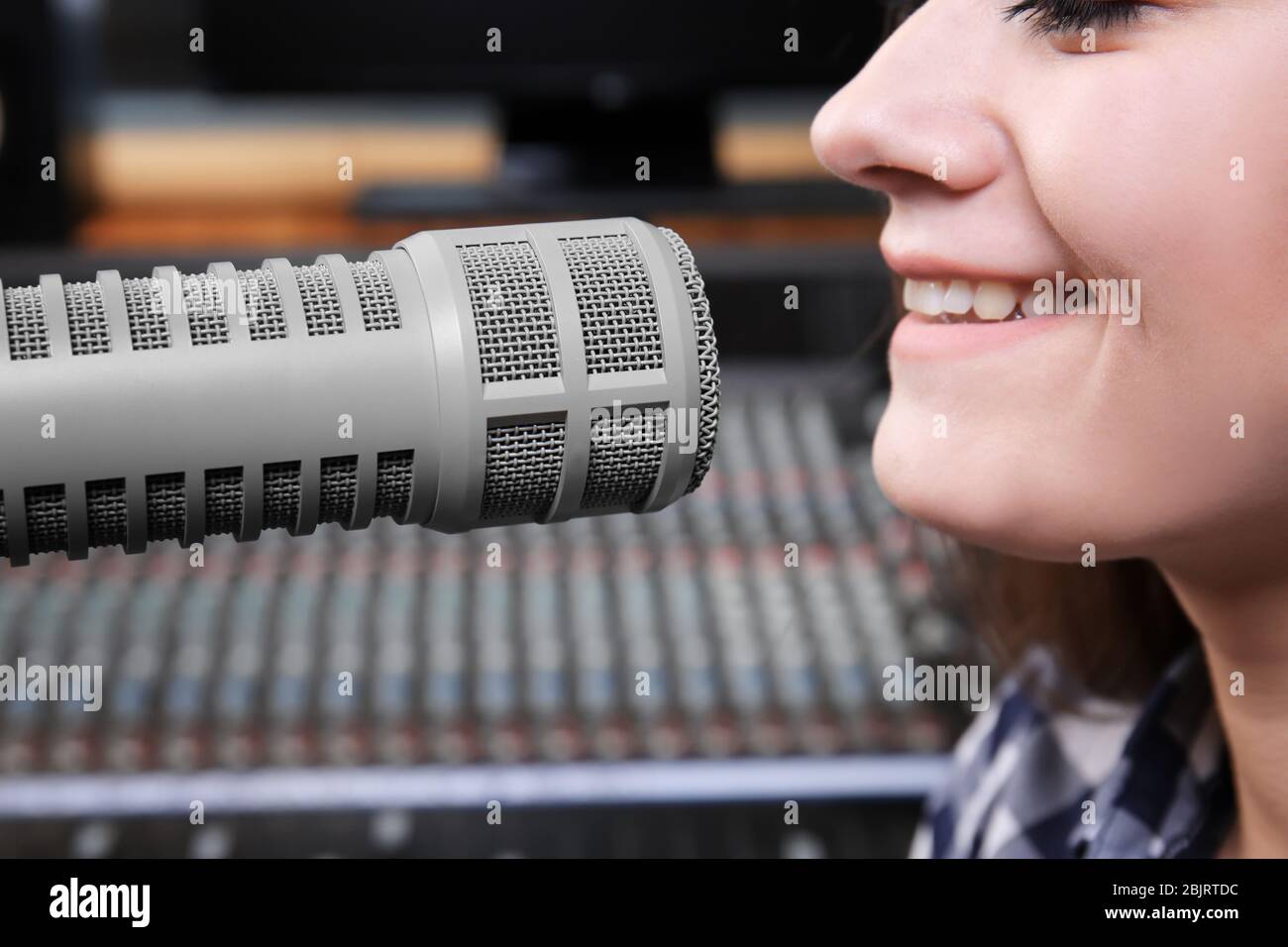 La radio hôte féminine diffuse par microphone en studio Banque D'Images