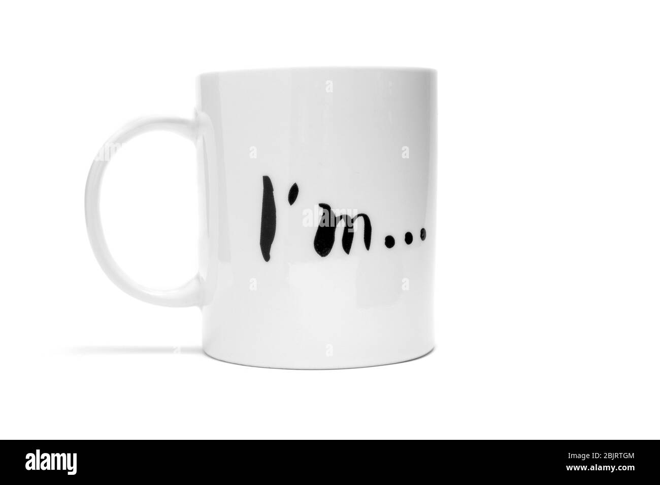 Mug blanc avec l'inscription « Je suis... » sur un fond blanc. Isoler Banque D'Images