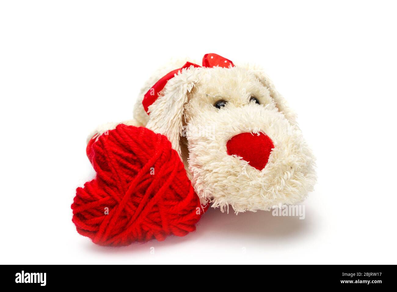 Coeur tricoté rouge et petit chien doux et doux avec un nez rouge pour la Saint-Valentin sur fond blanc, isoler .gros plan Banque D'Images