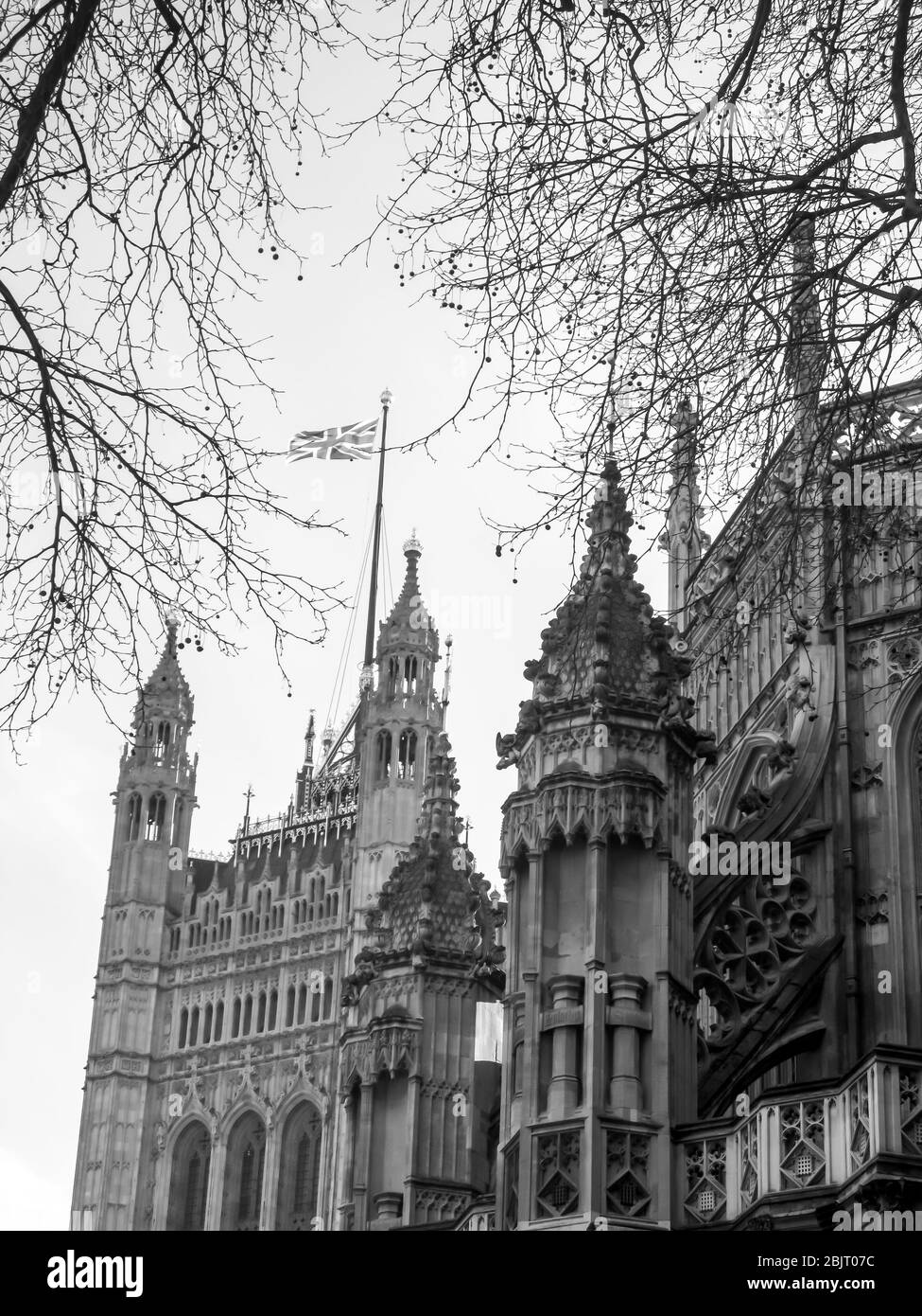 Un gros plan monochrome de la pierre de l'abbaye de Westminster avec la tour Victoria des chambres du Parlement en arrière-plan, Londres, Royaume-Uni Banque D'Images